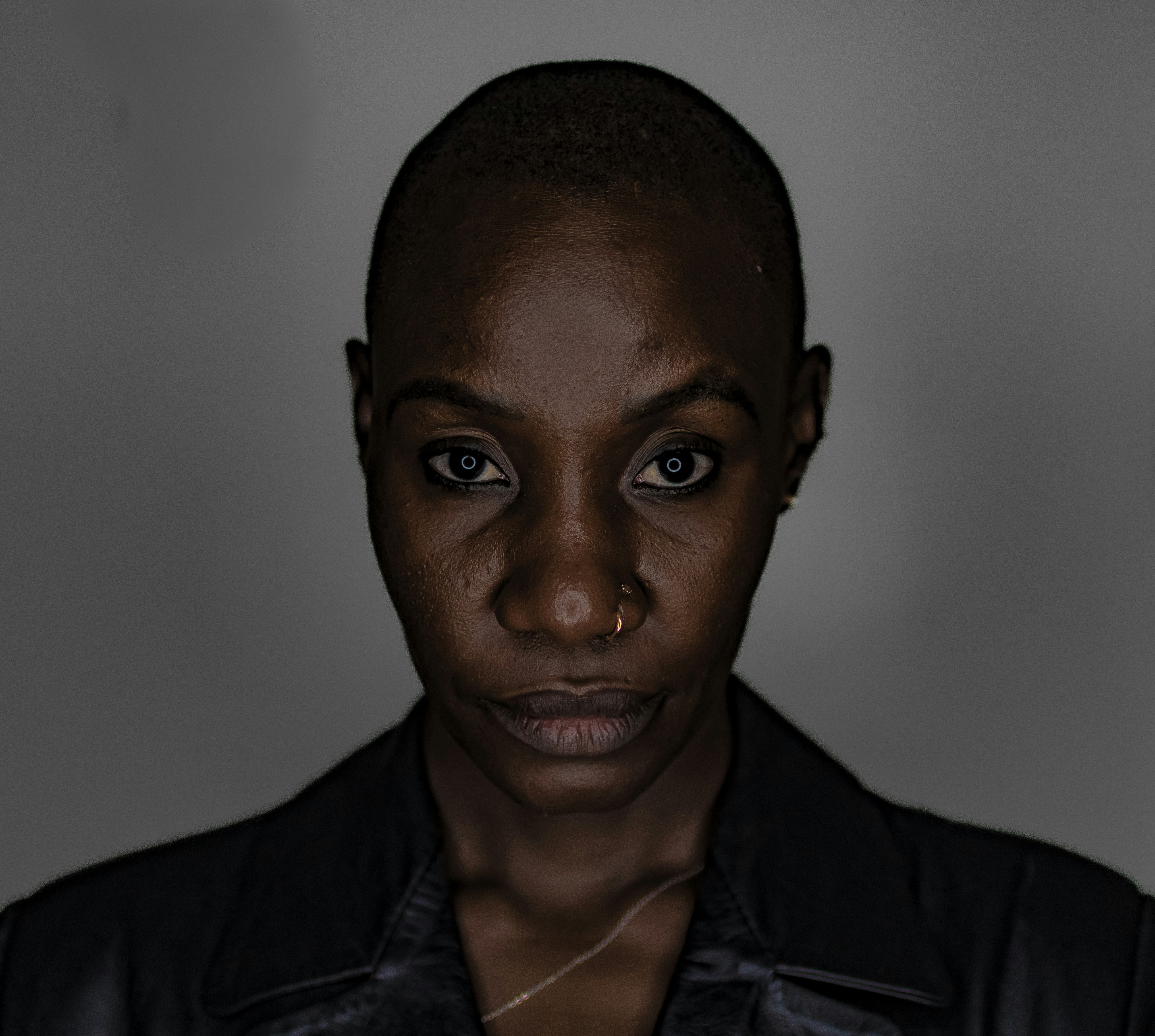 A close-up of a woman with a shaved head.