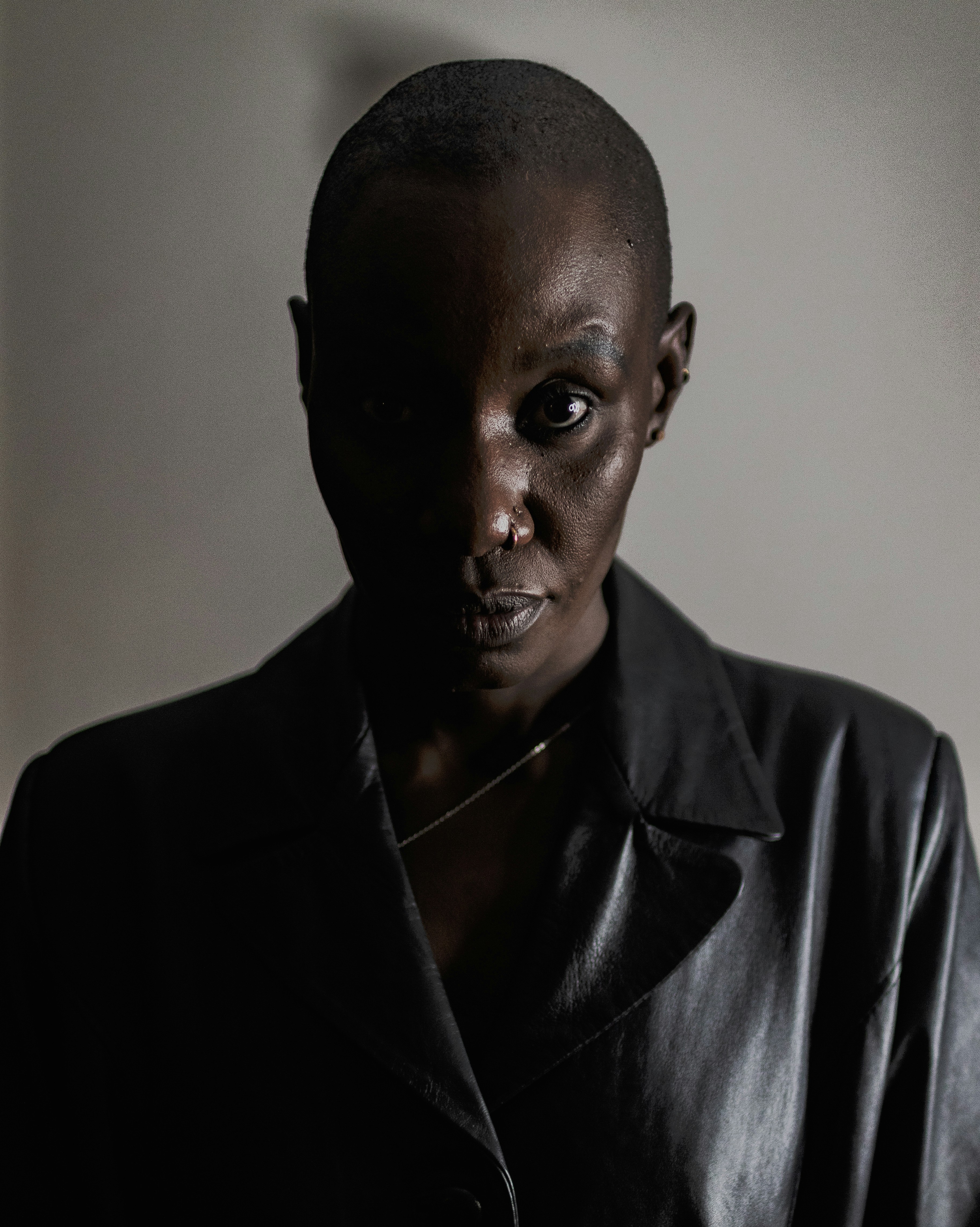 A bald woman in a dark leather jacket