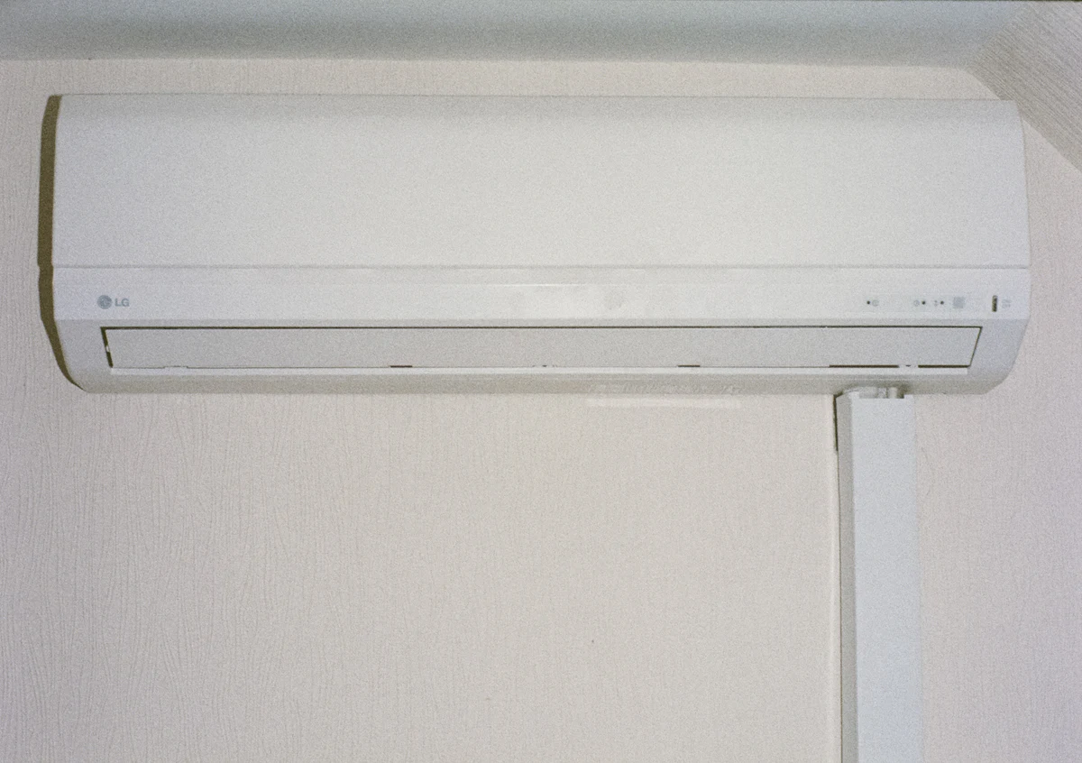Unidad interior de un aire acondicionado split blanco instalada en una pared clara
