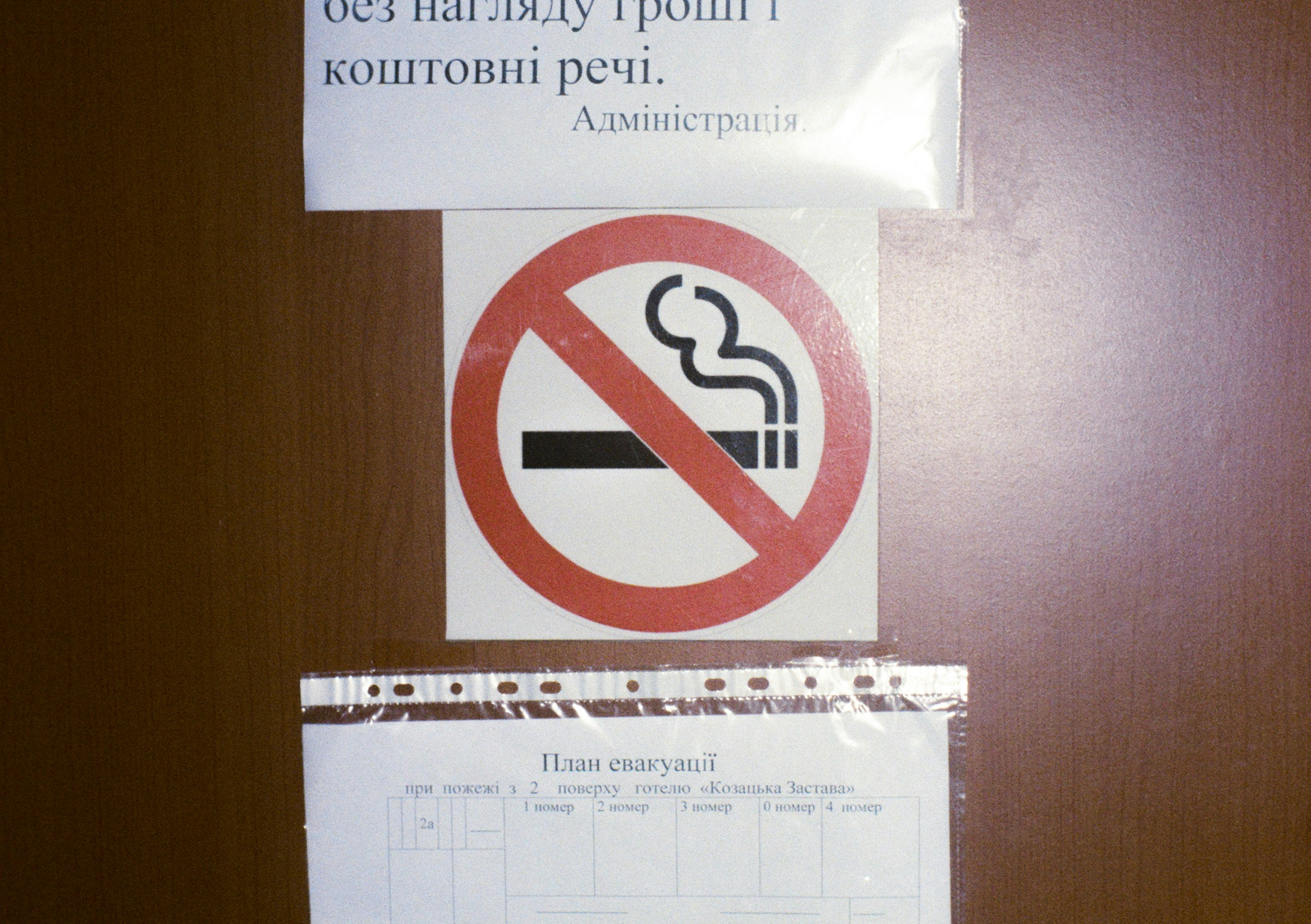 Rauchverbotsschild mit Text oben und Papieren