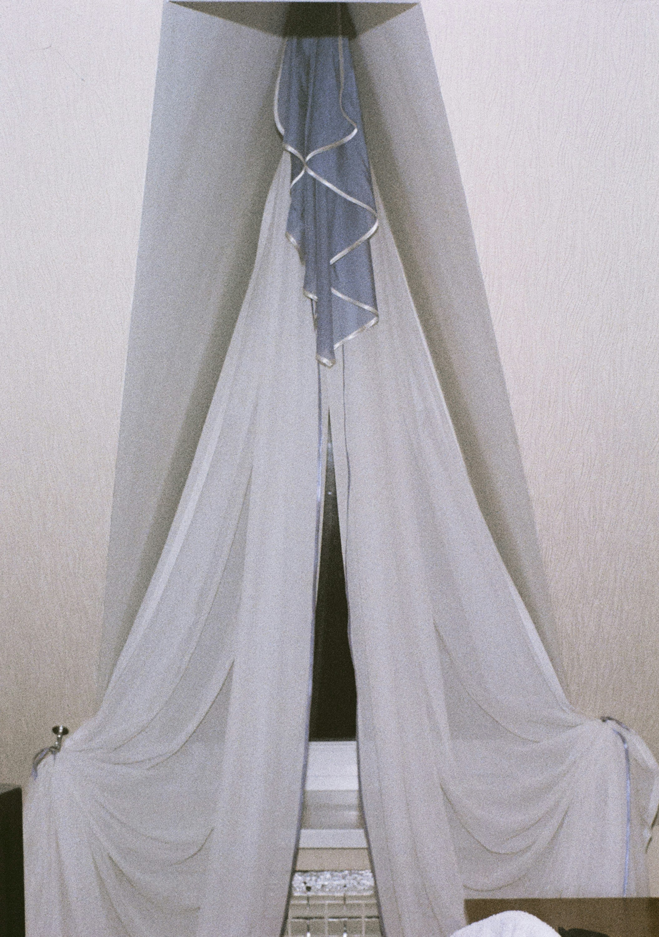 A sheer canopy drapes over a bed.