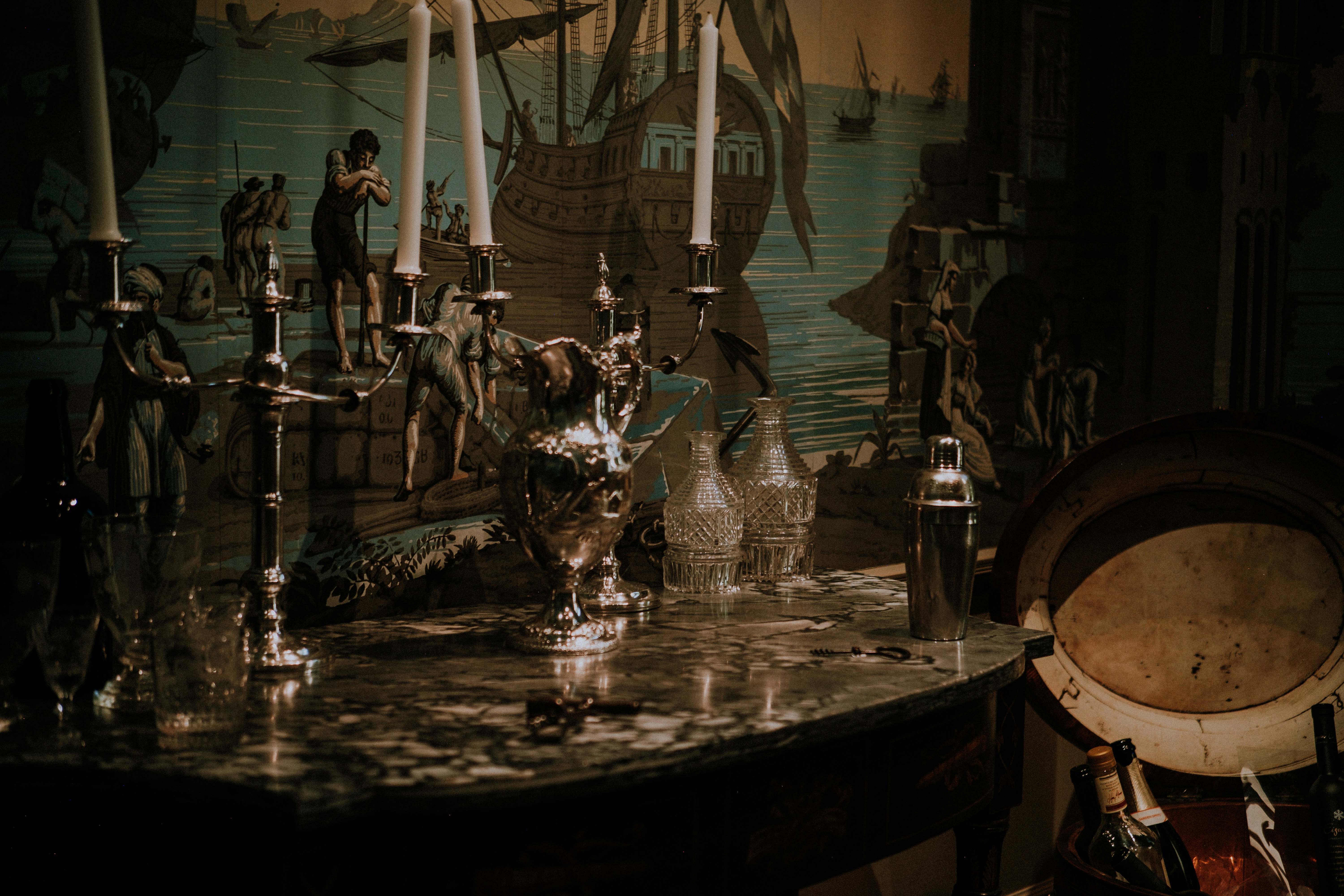 Antique candelabra on a table with mural