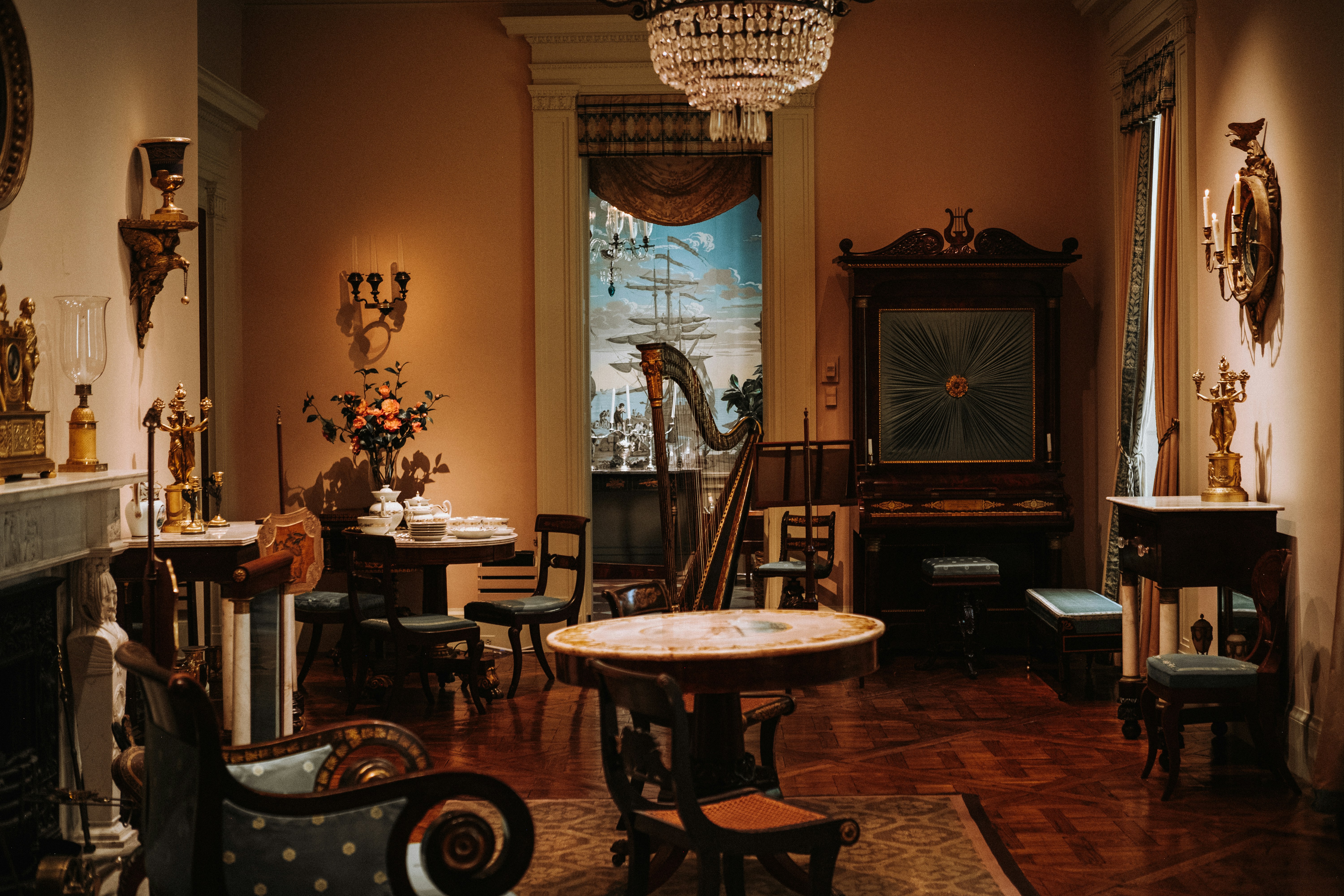 Elegant antique parlor with harp and ornate furniture.