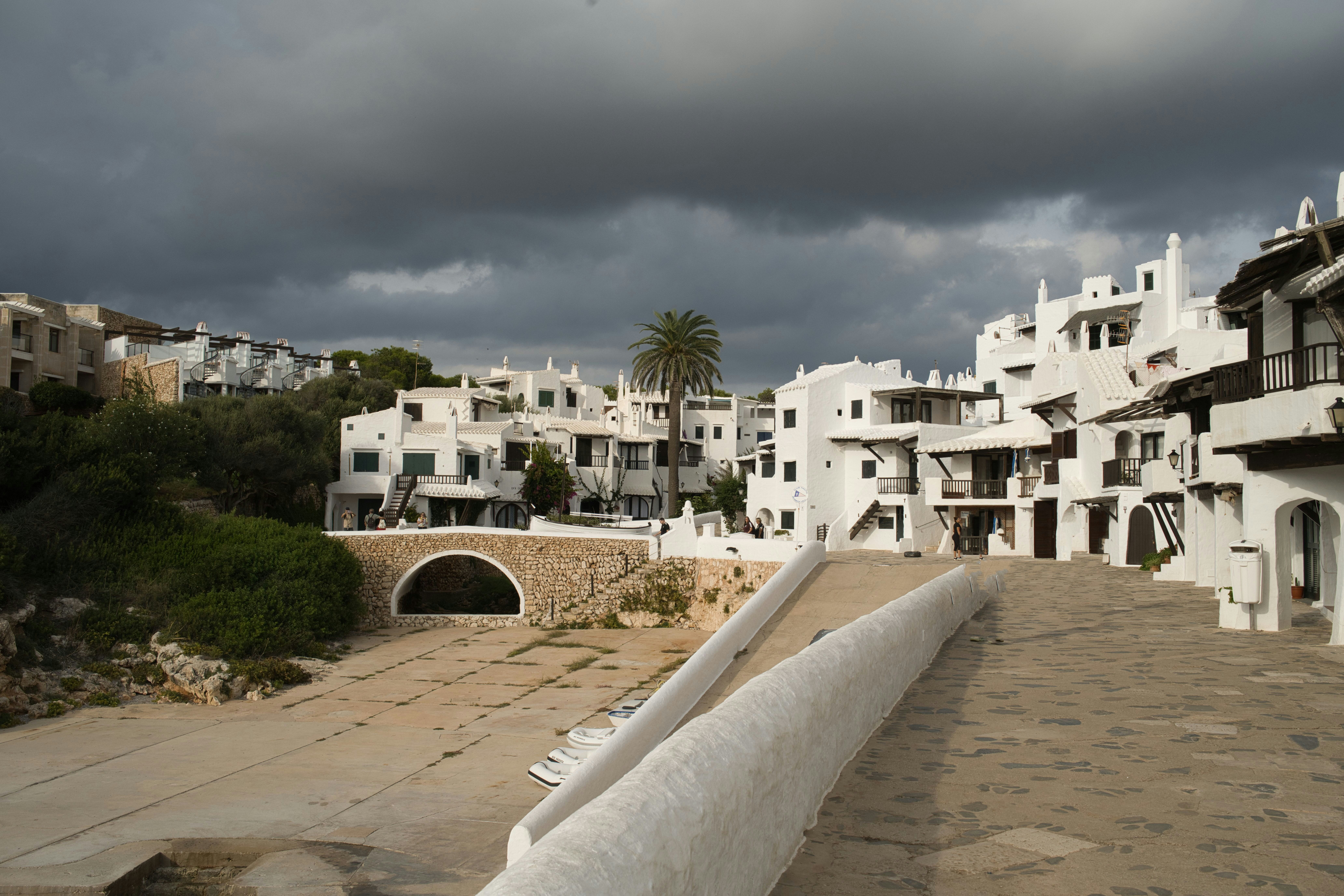 White buildings on a hillside under cloudy sky