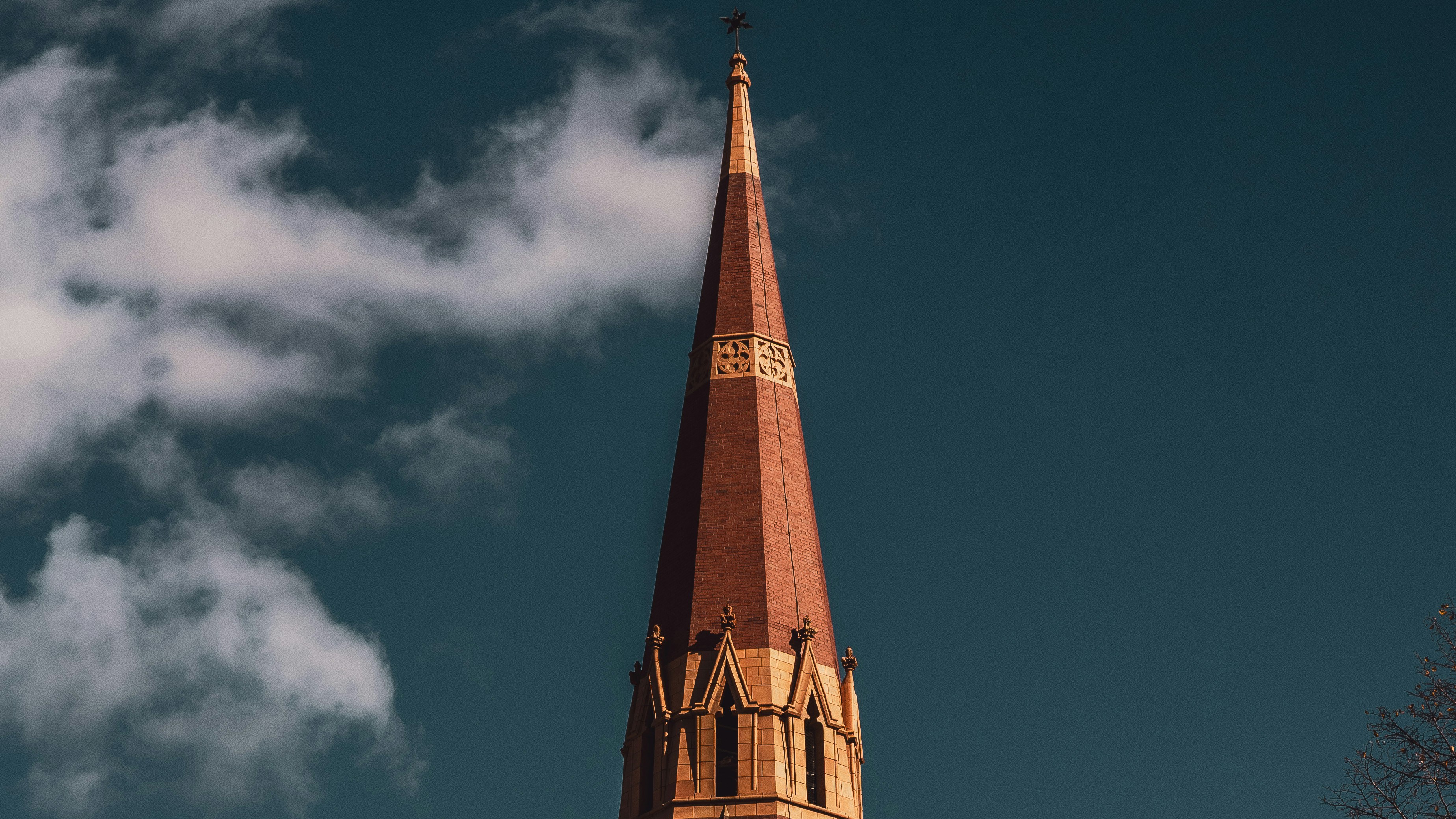 Tall steeple against a cloudy blue sky