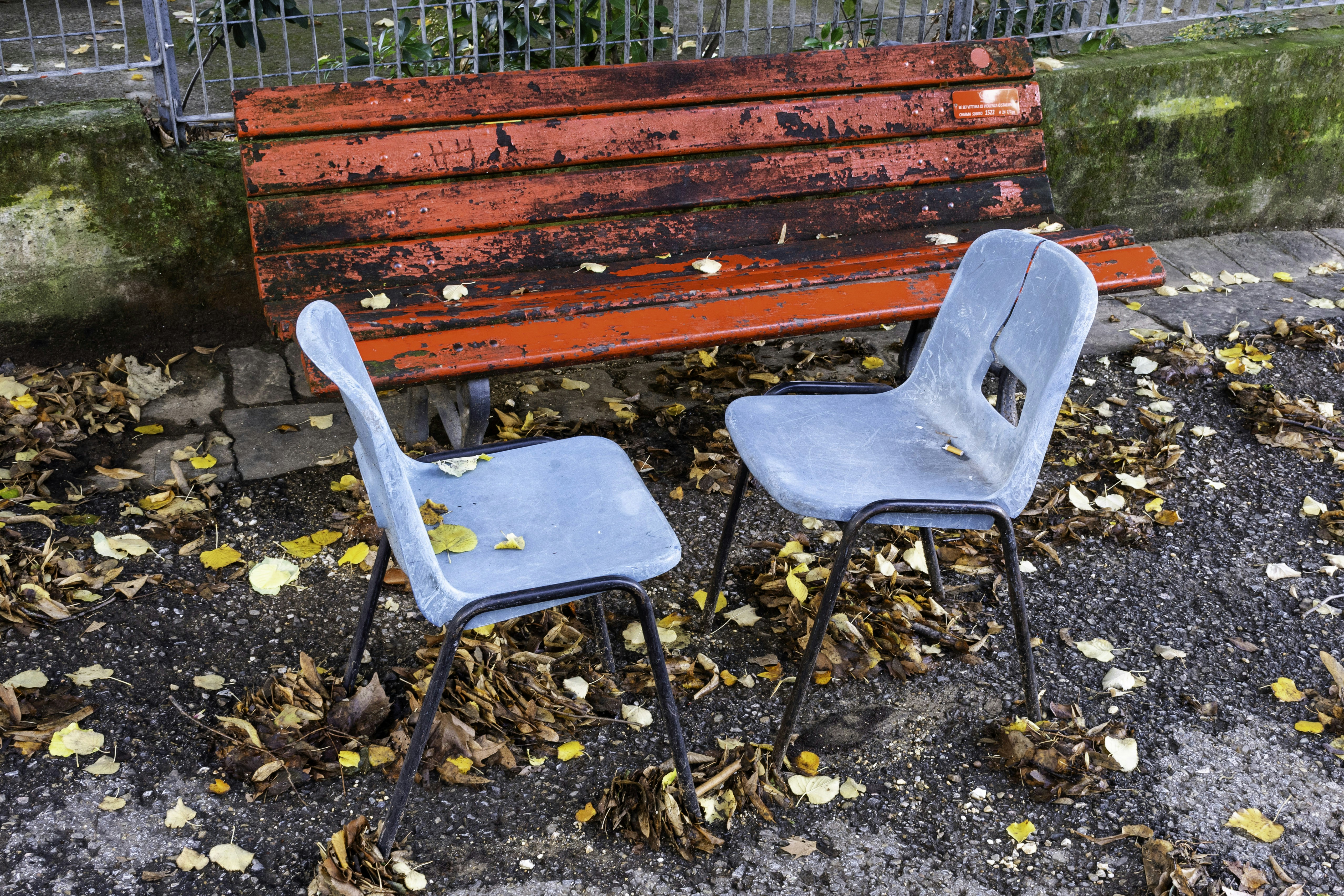 Deux chaises bleues devant un banc rouge
