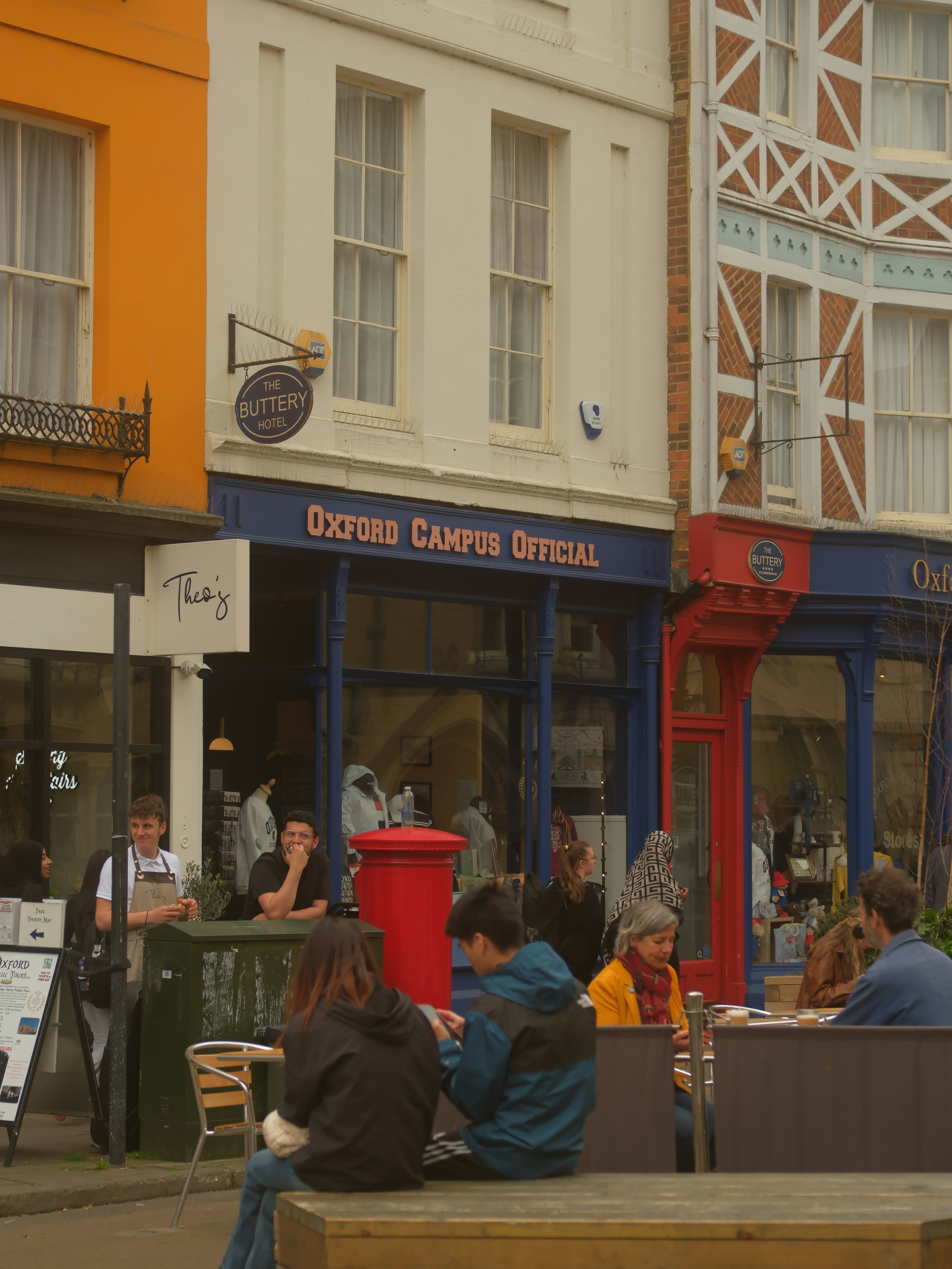People sitting at outdoor cafe in front of shops