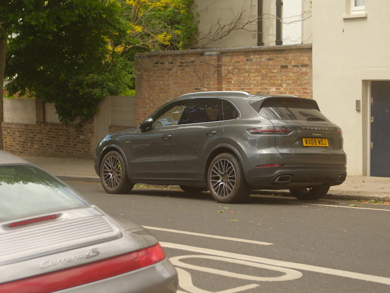 A grey Porsche Cayenne parked on a street, understated elegance