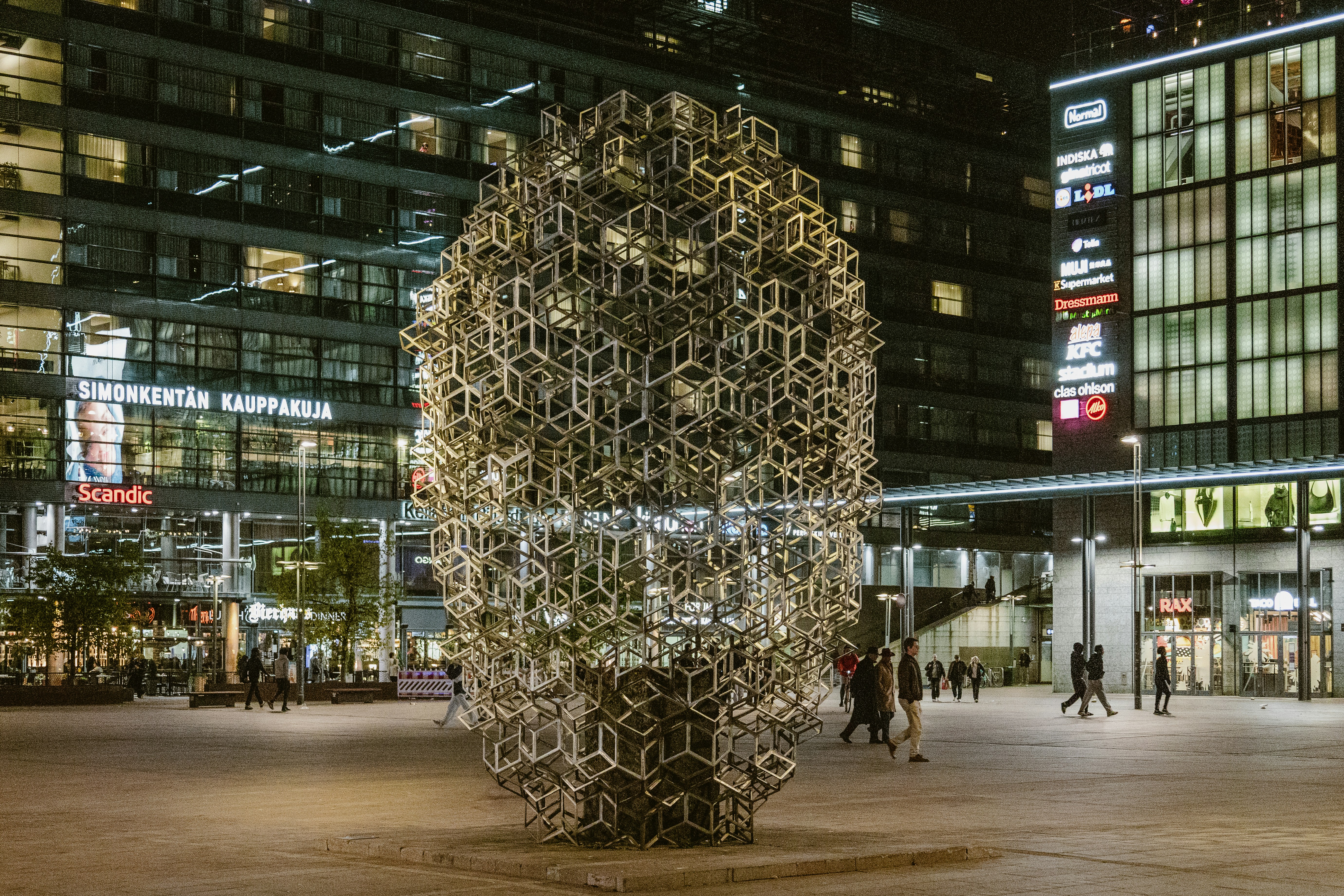 Scultura moderna in una piazza della città di notte