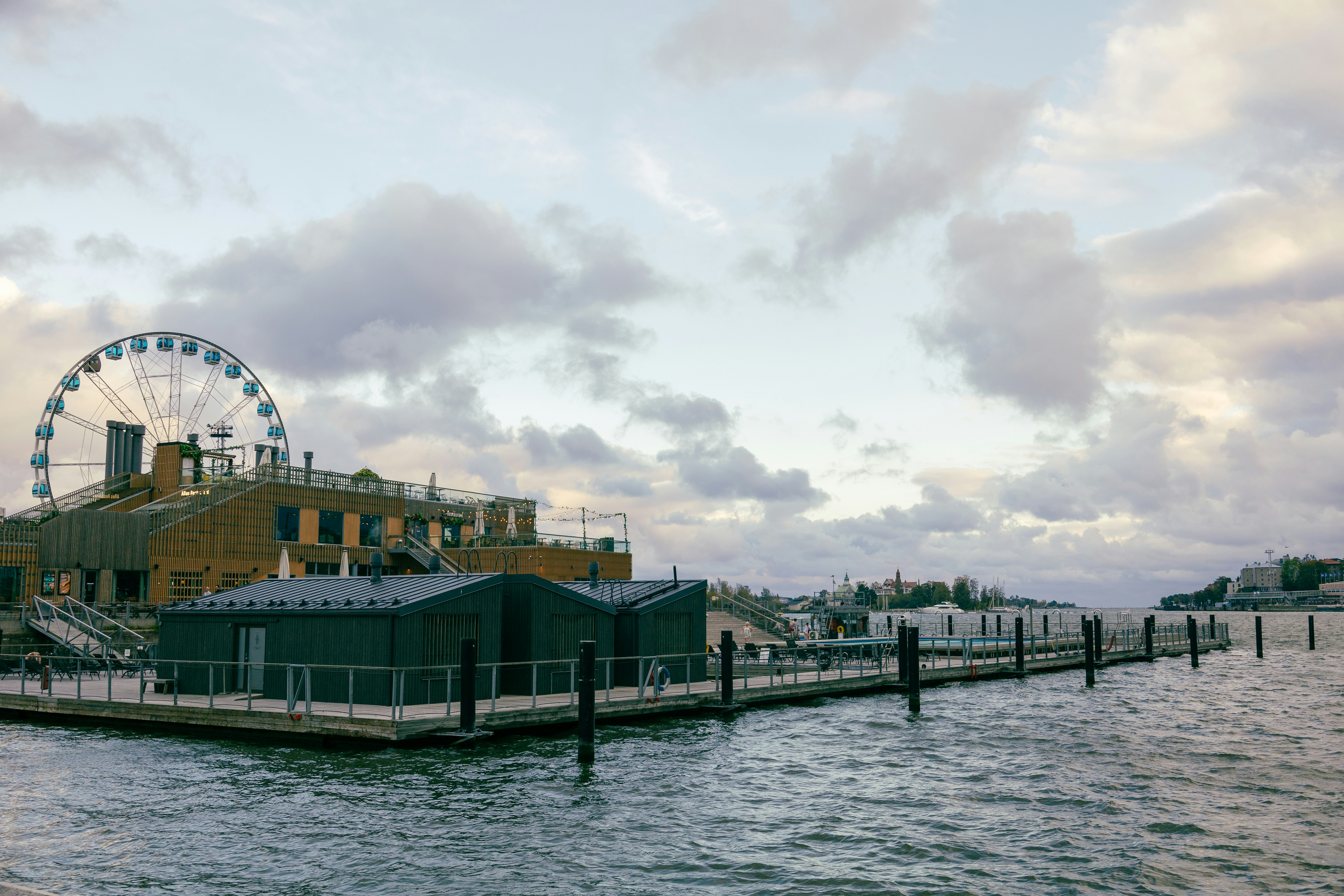 Ruota panoramica vicino all'acqua sotto un cielo nuvoloso