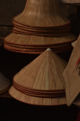 Stack of conical straw hats with brown trim