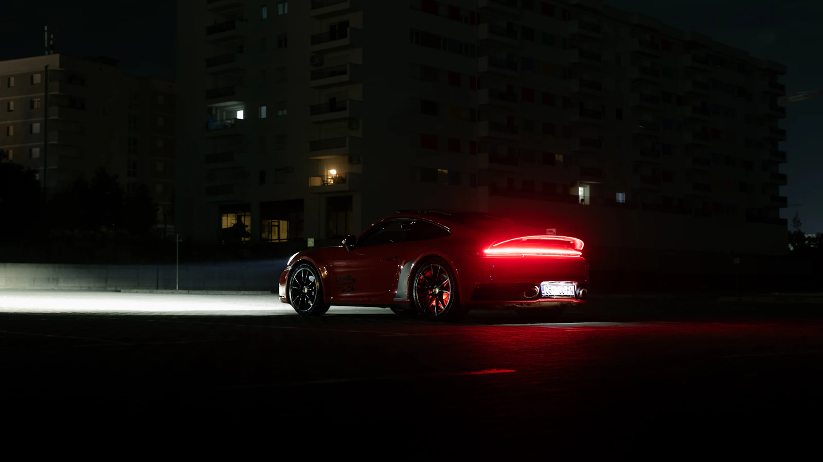 Vehículo deportivo rojo con luces encendidas de noche