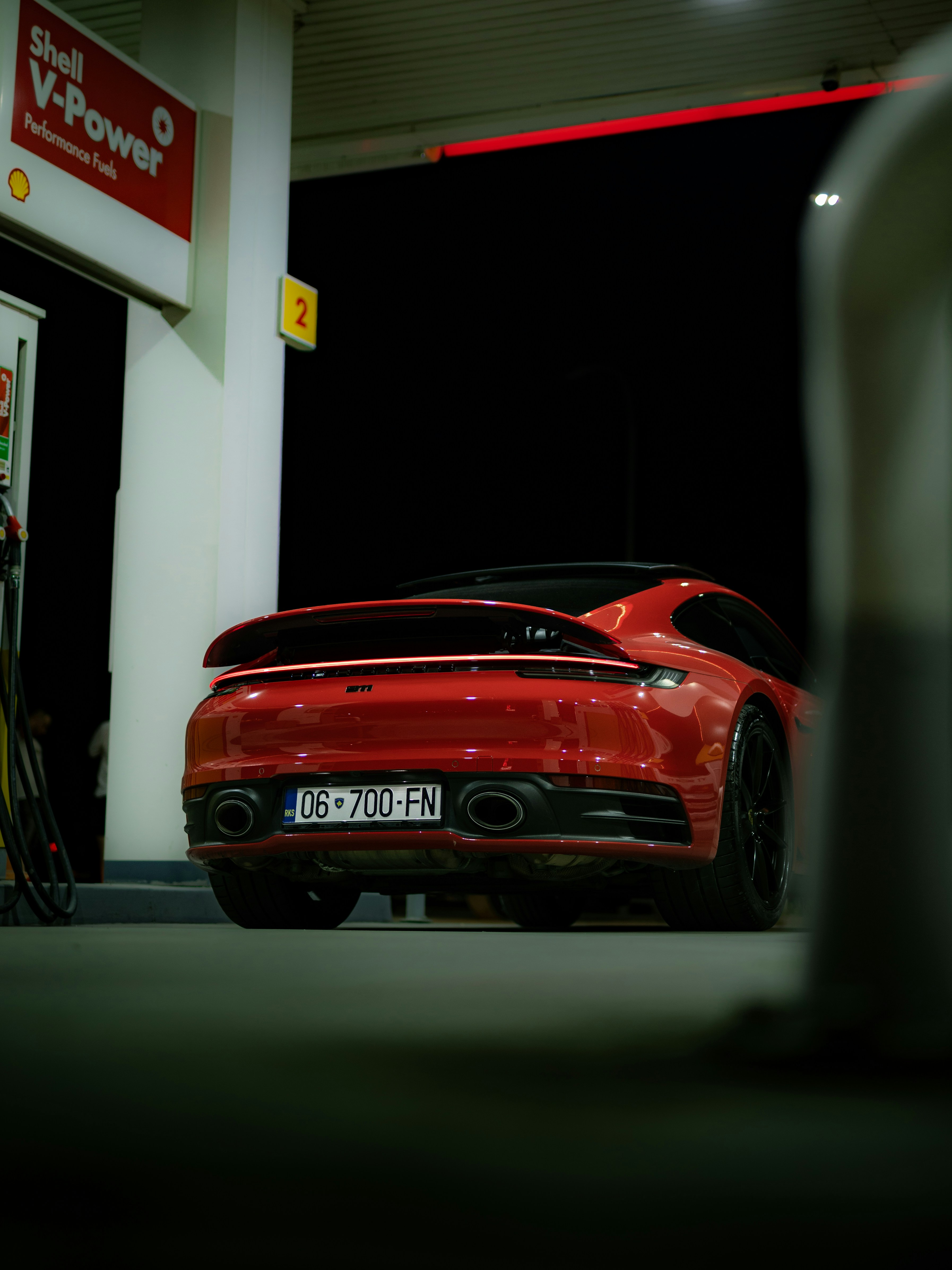 Red sports car at a gas station at night