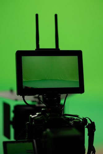 Green screen film set with camera equipment and crew preparing a shot