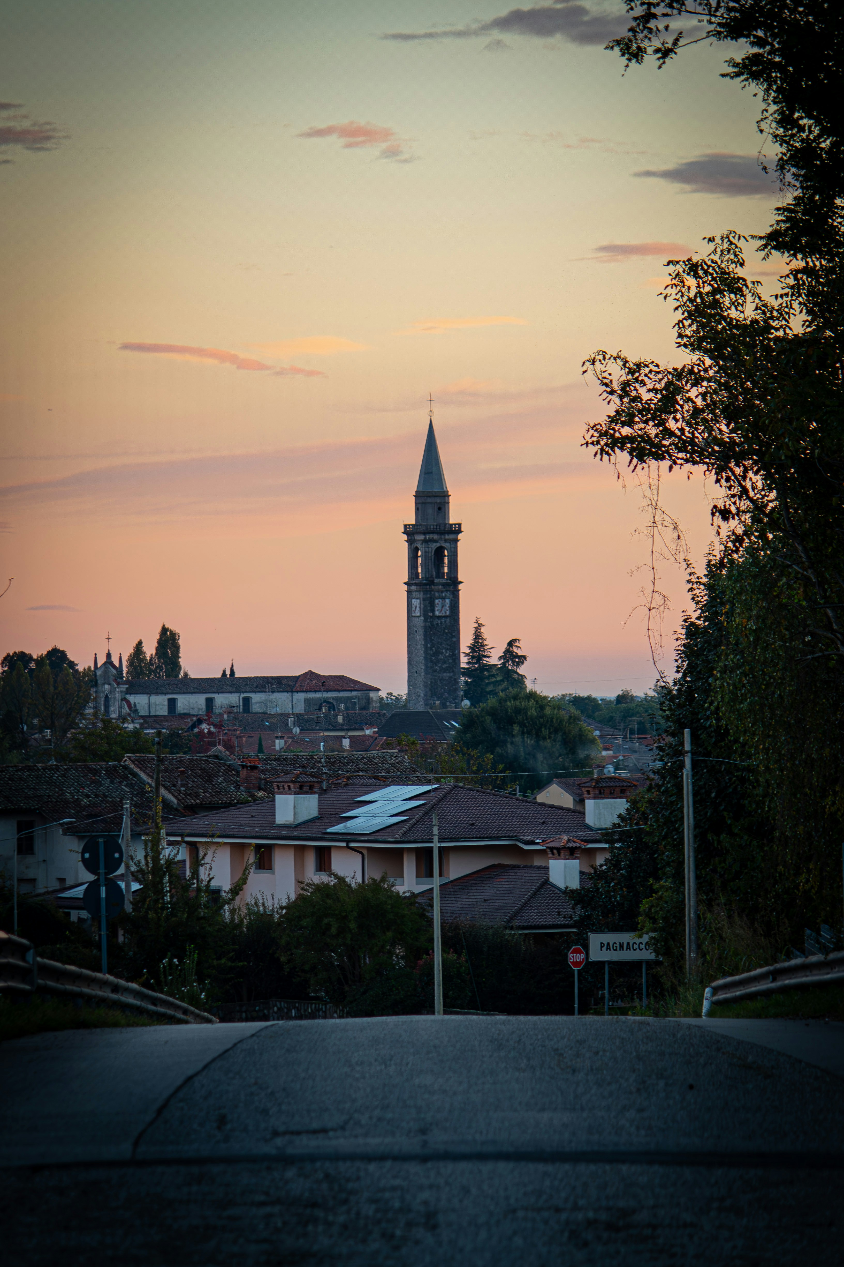 Village church tower at sunset with pastel sky