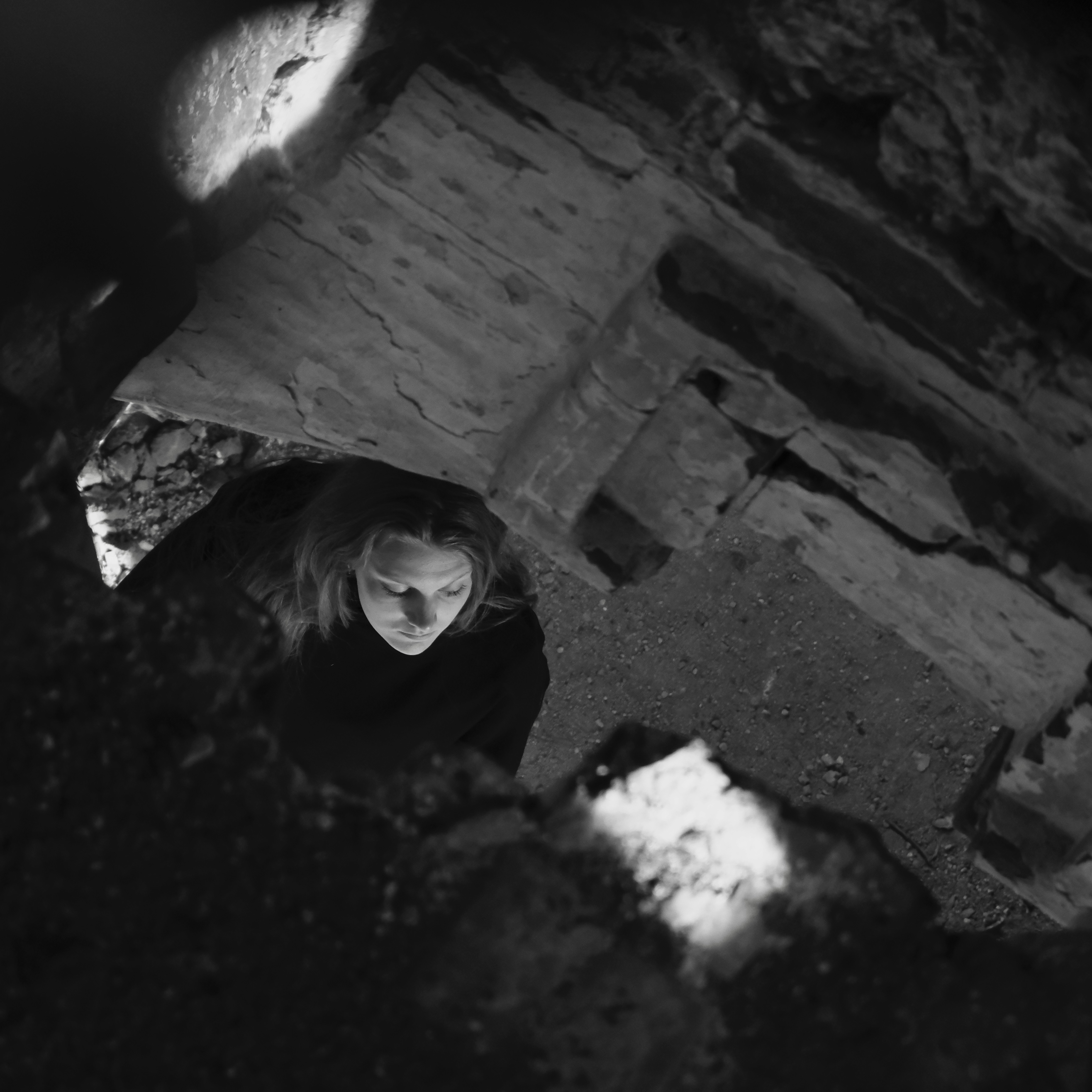 Eine Person, die aus einem dunklen, felsigen Loch nach oben schaut.