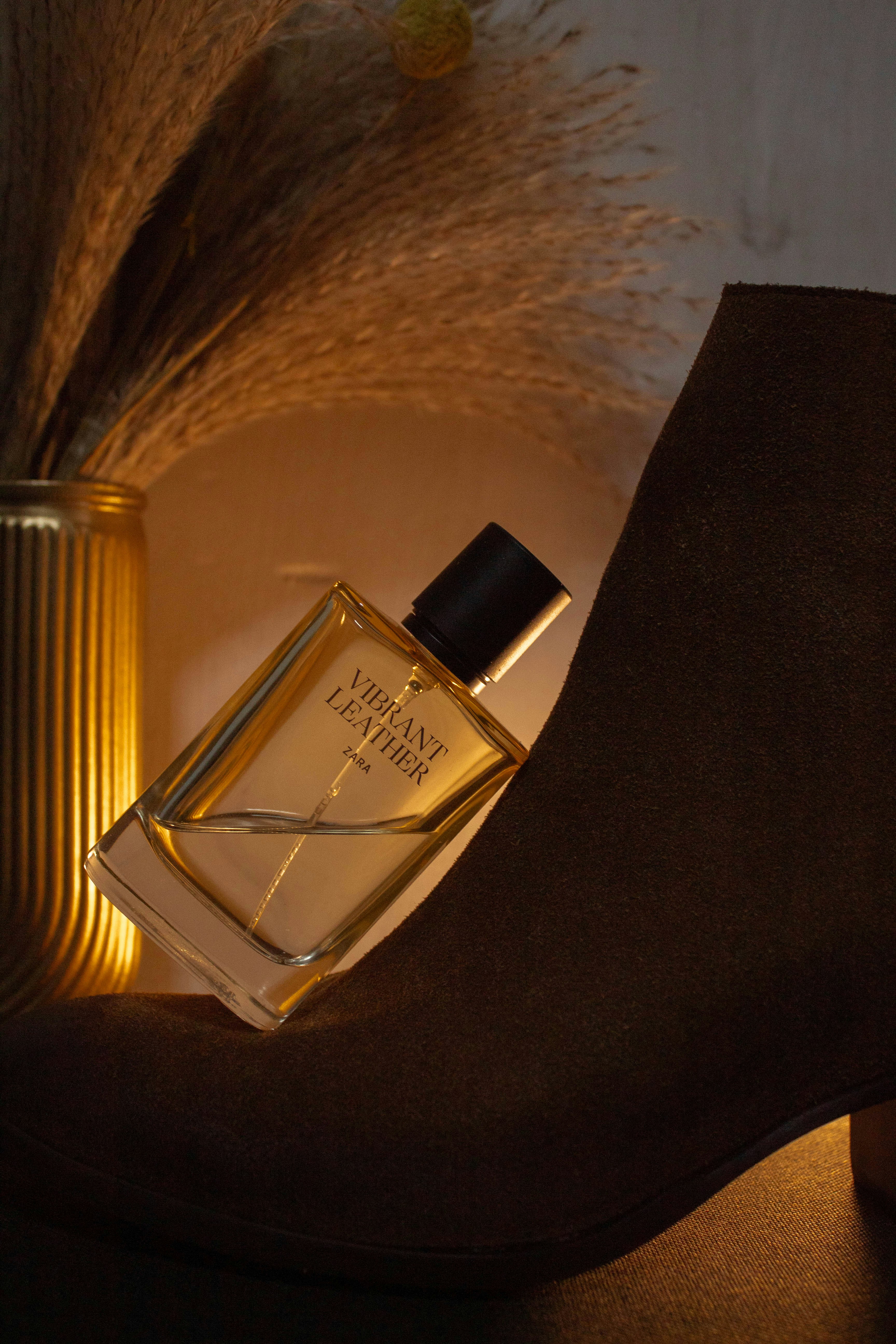 Perfume bottle resting on a brown boot