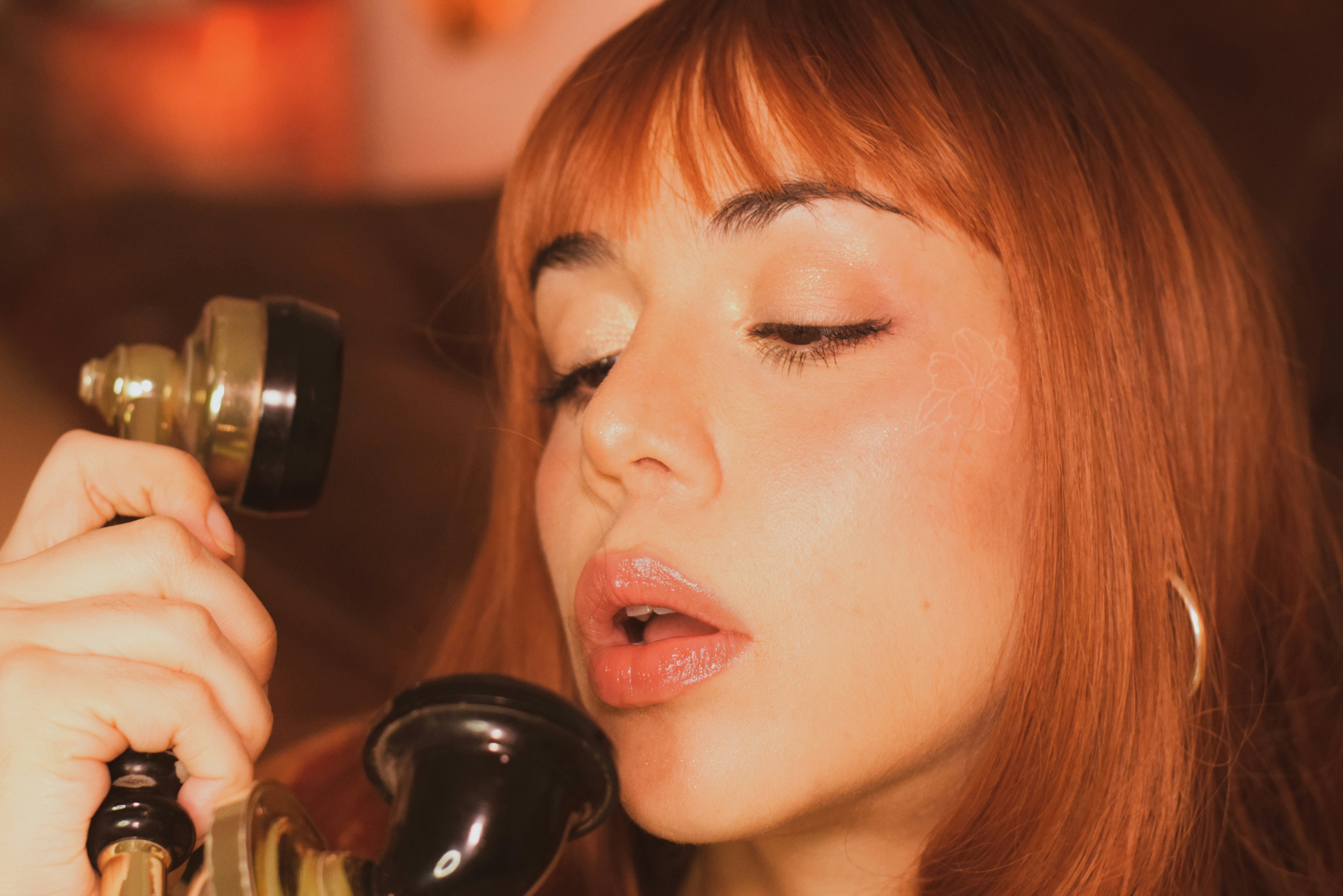 Woman with red hair holding an old telephone