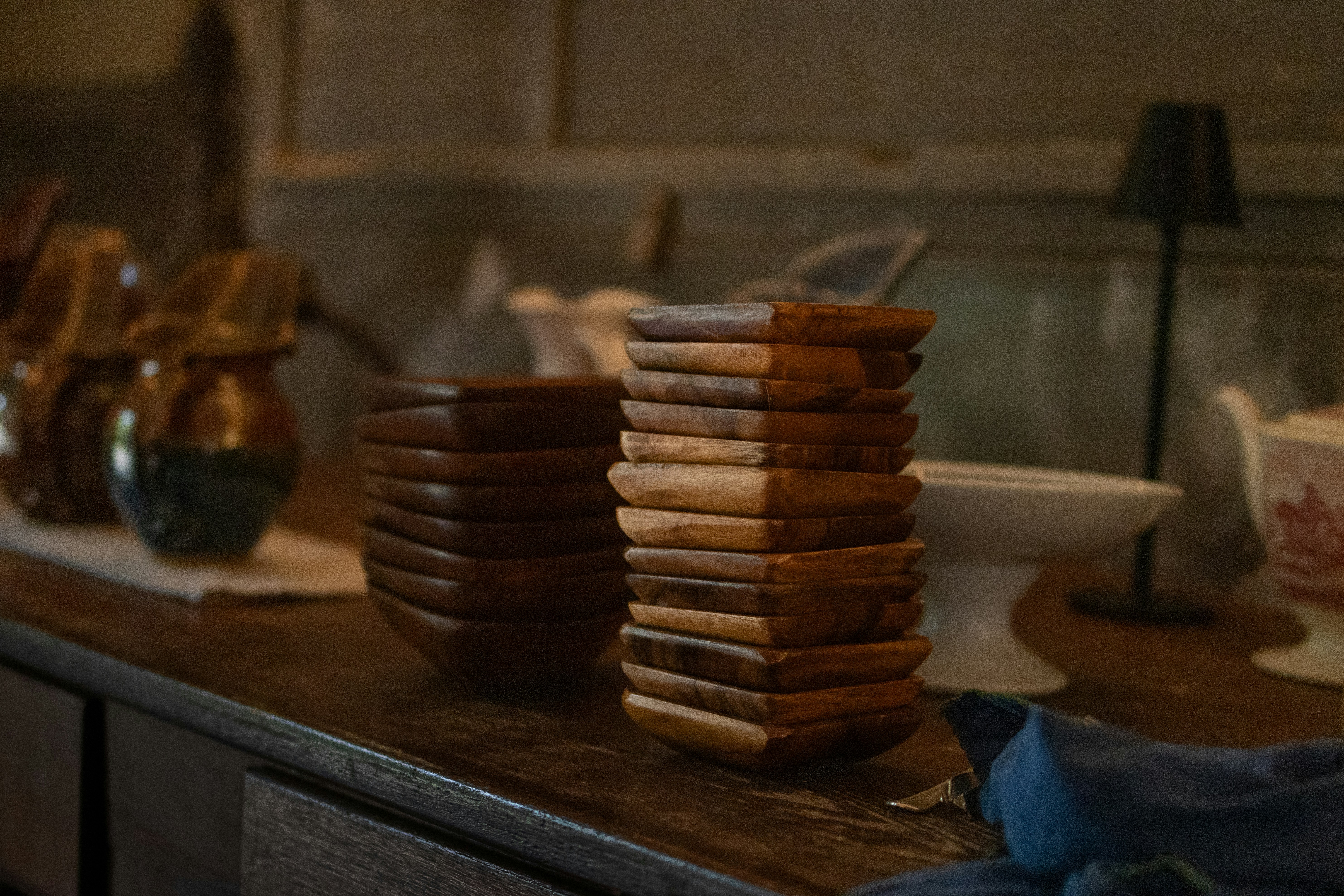 Stack of square wooden bowls on a shelf.