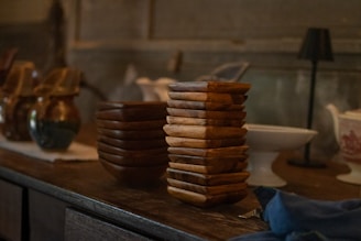 Stack of square wooden bowls on a shelf.