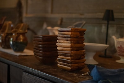 Stack of square wooden bowls on a shelf.