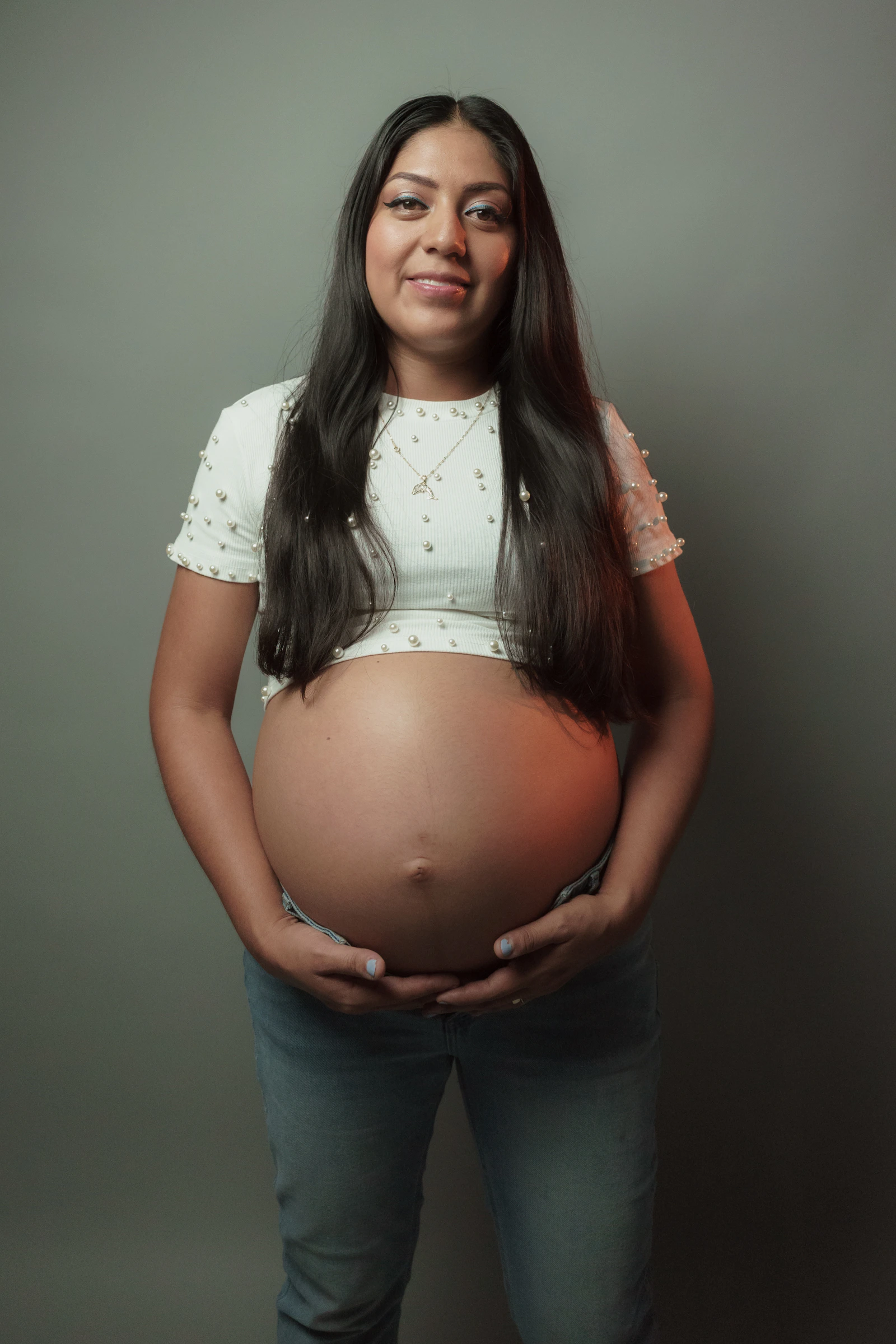 Una mujer embarazada sostiene su barriga con las manos