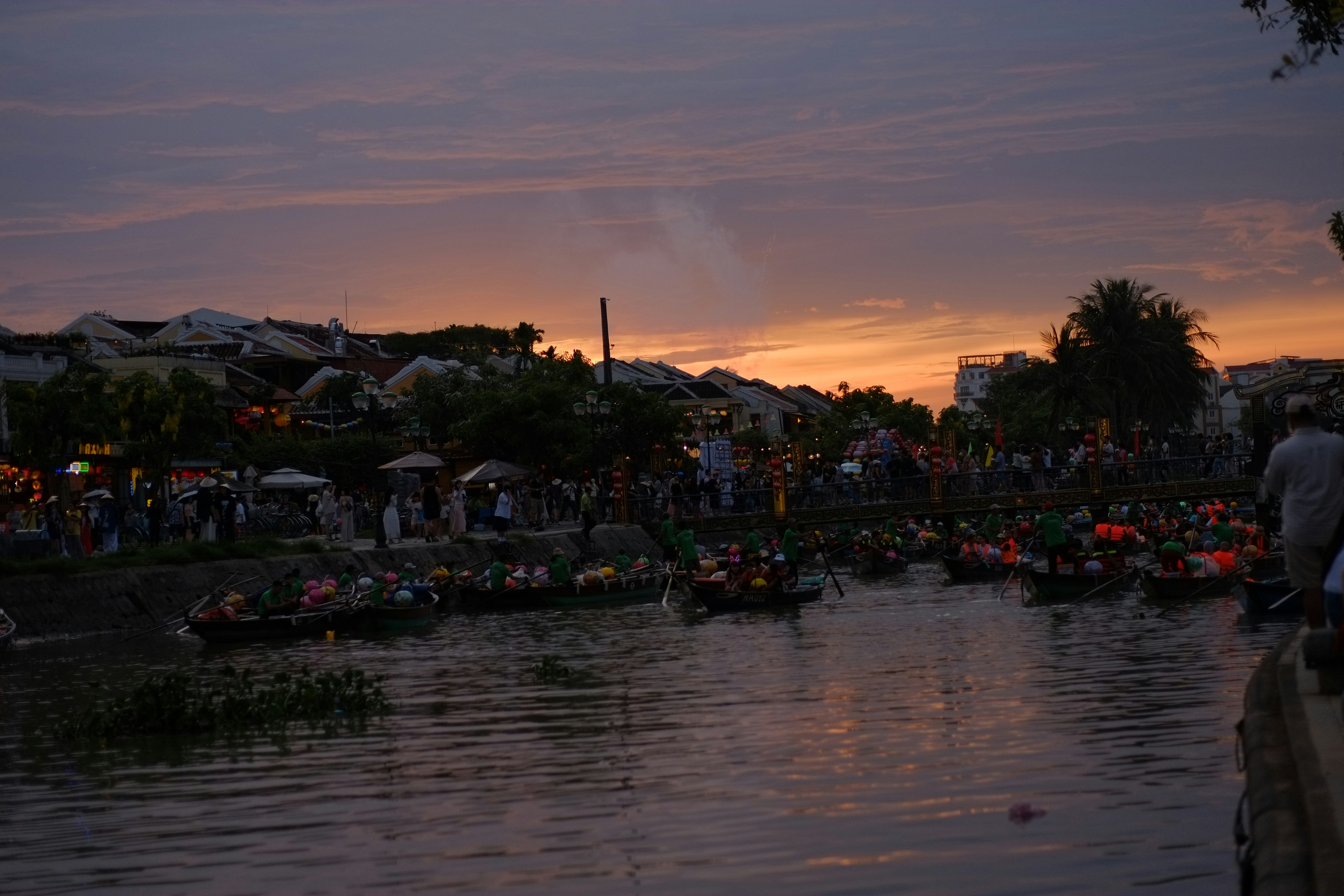 A riverside scene at dusk with festival lanterns