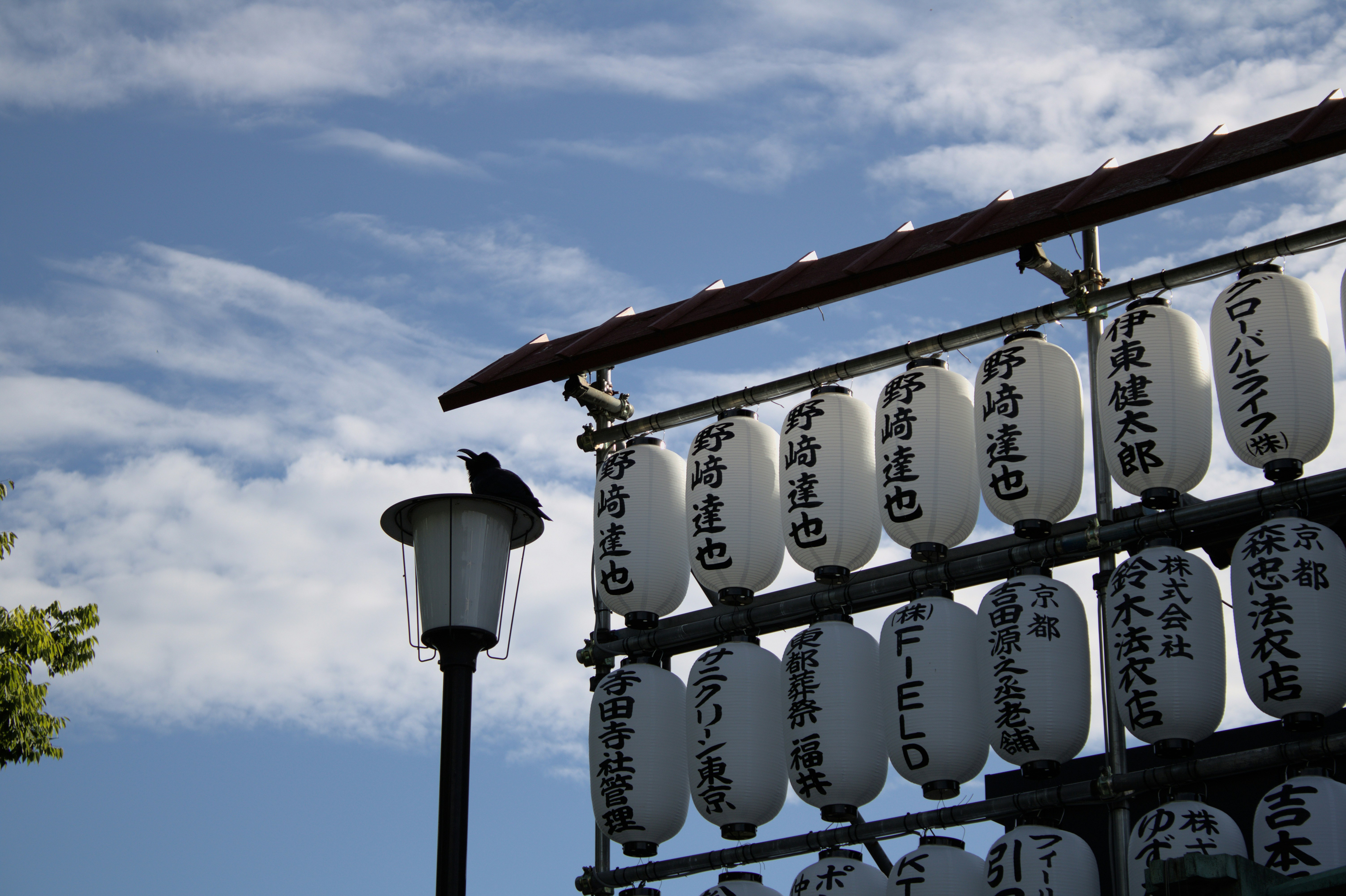 White lanterns hang under a blue sky.