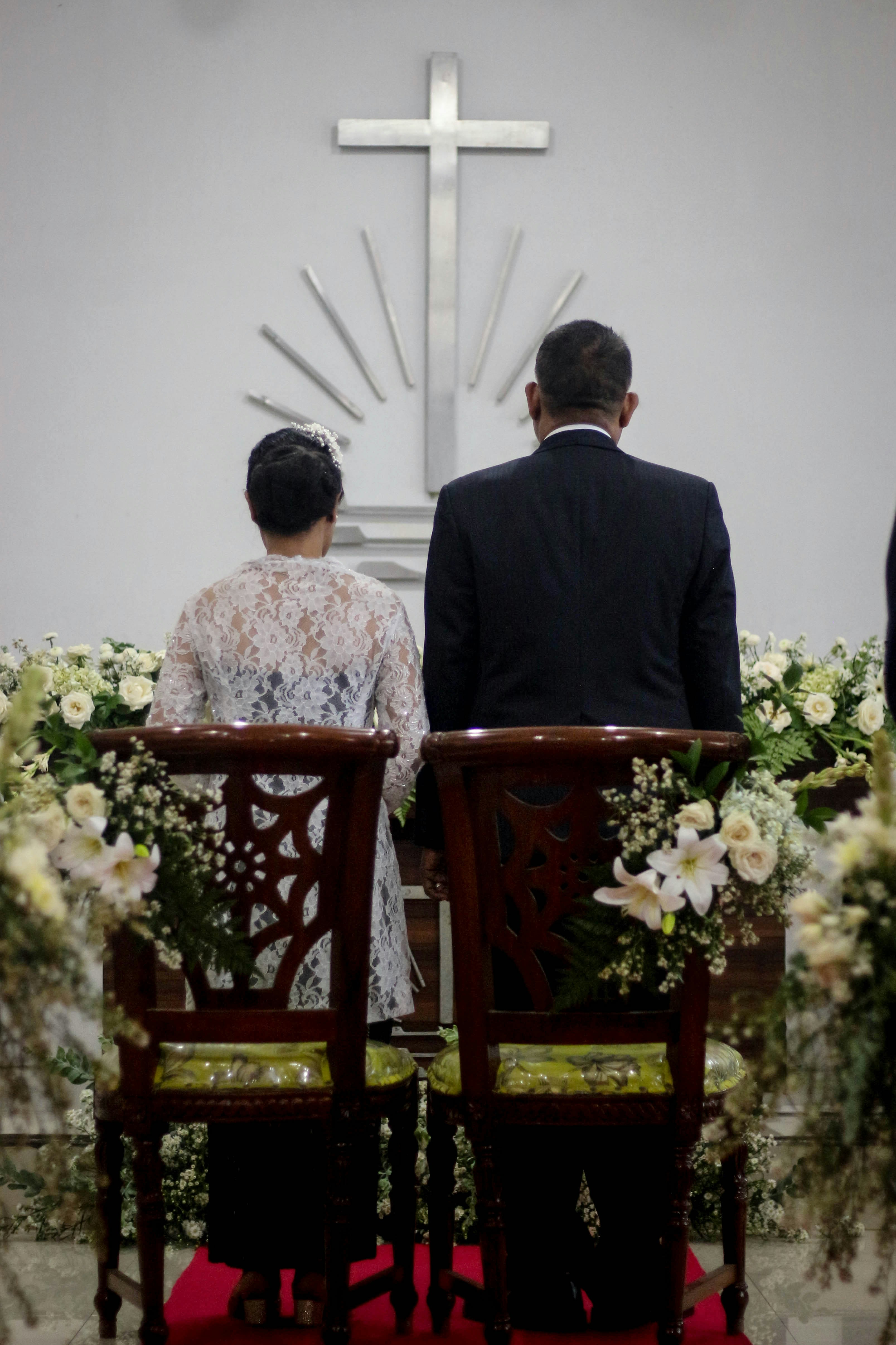 Couple standing before a cross in a church