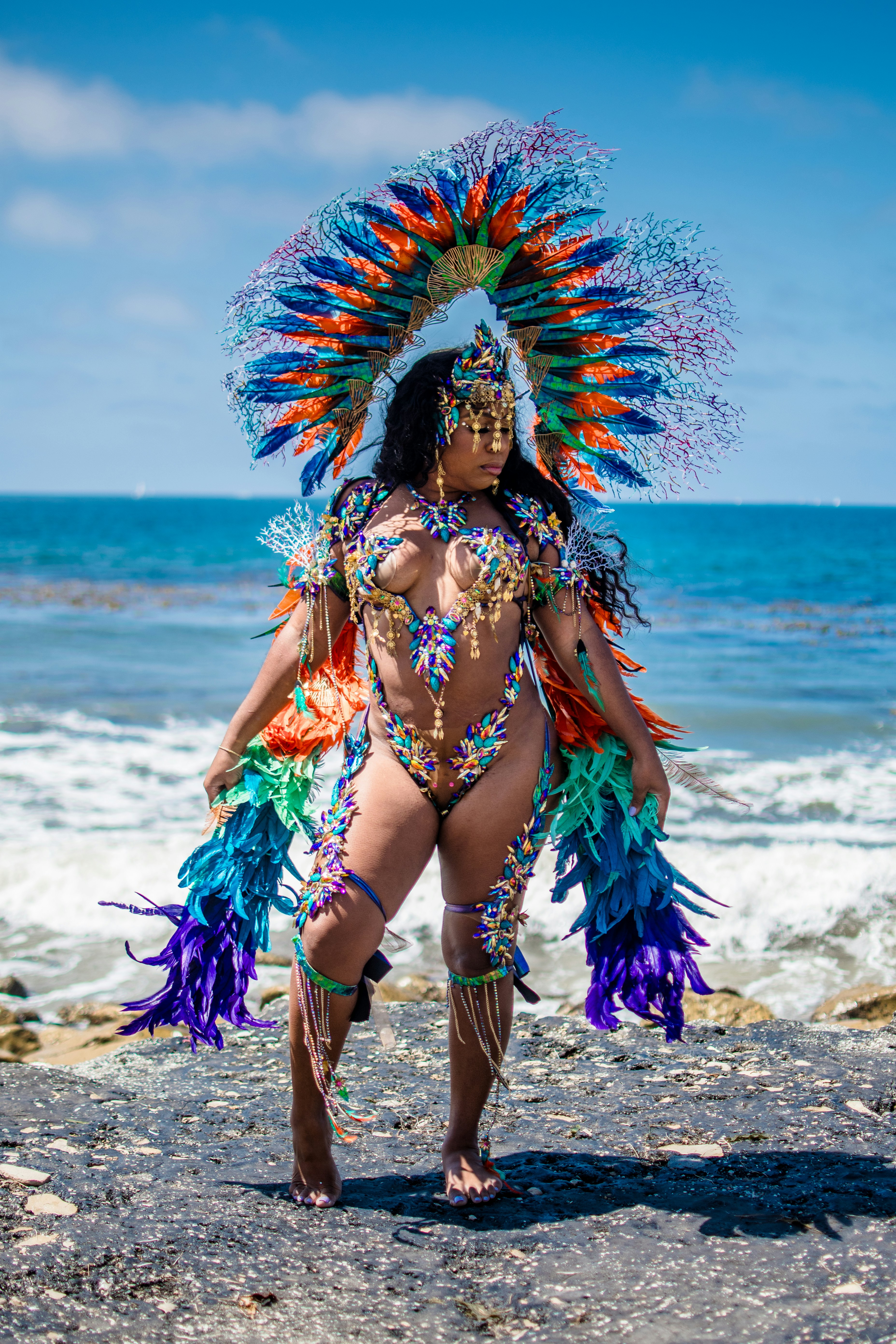 Woman in elaborate carnival costume on beach
