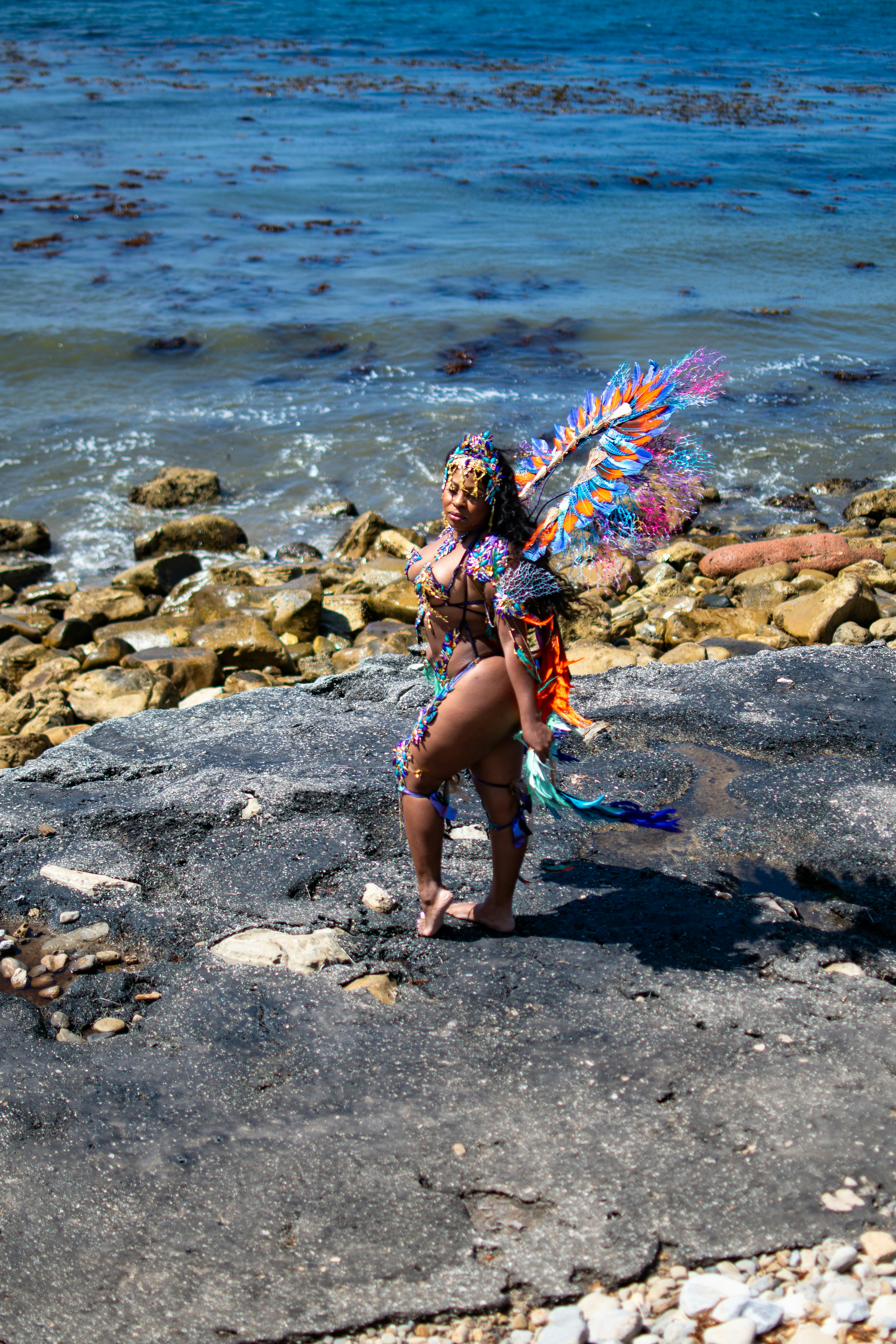Woman in colorful carnival costume by the ocean