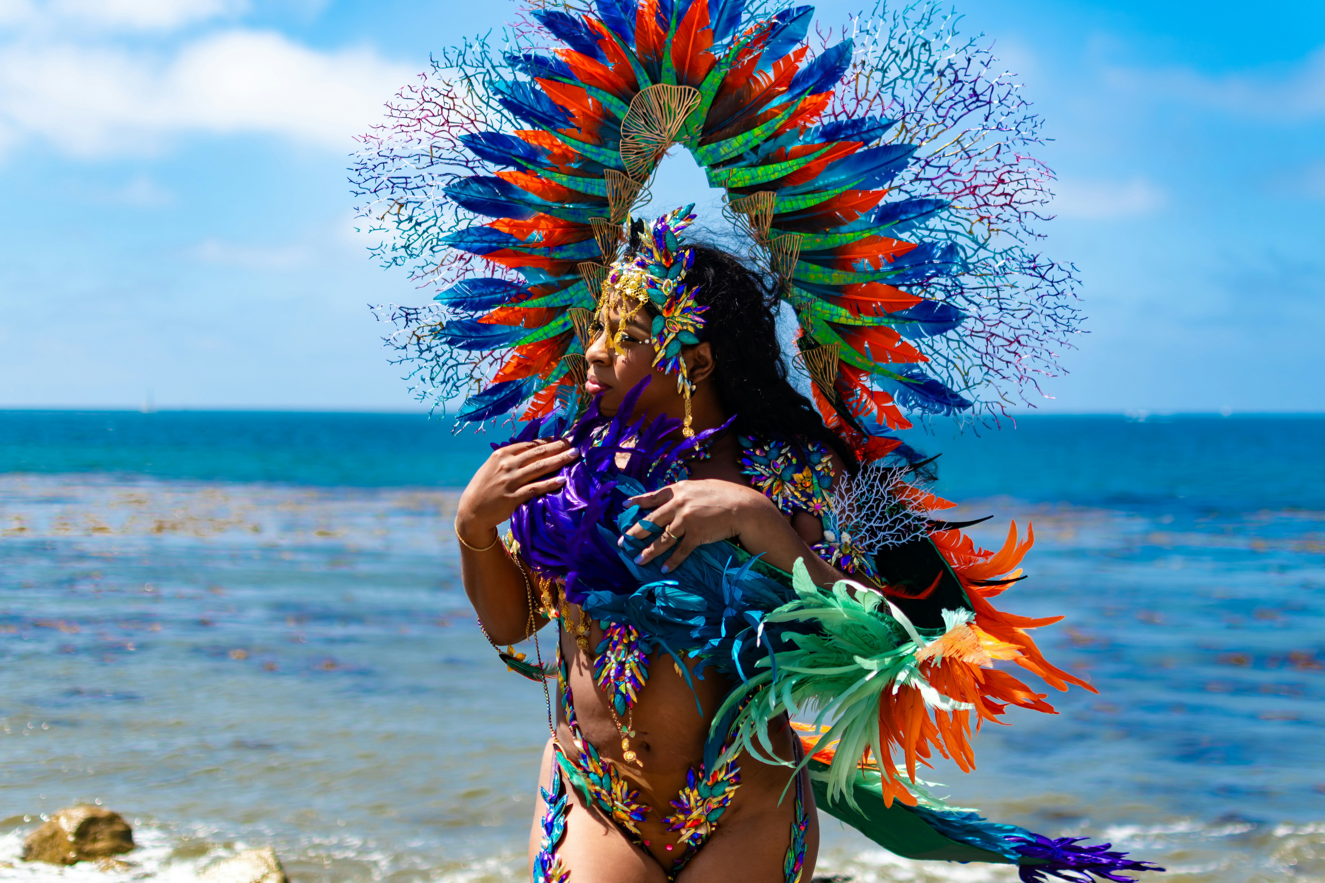 Woman in colorful carnival costume by the ocean