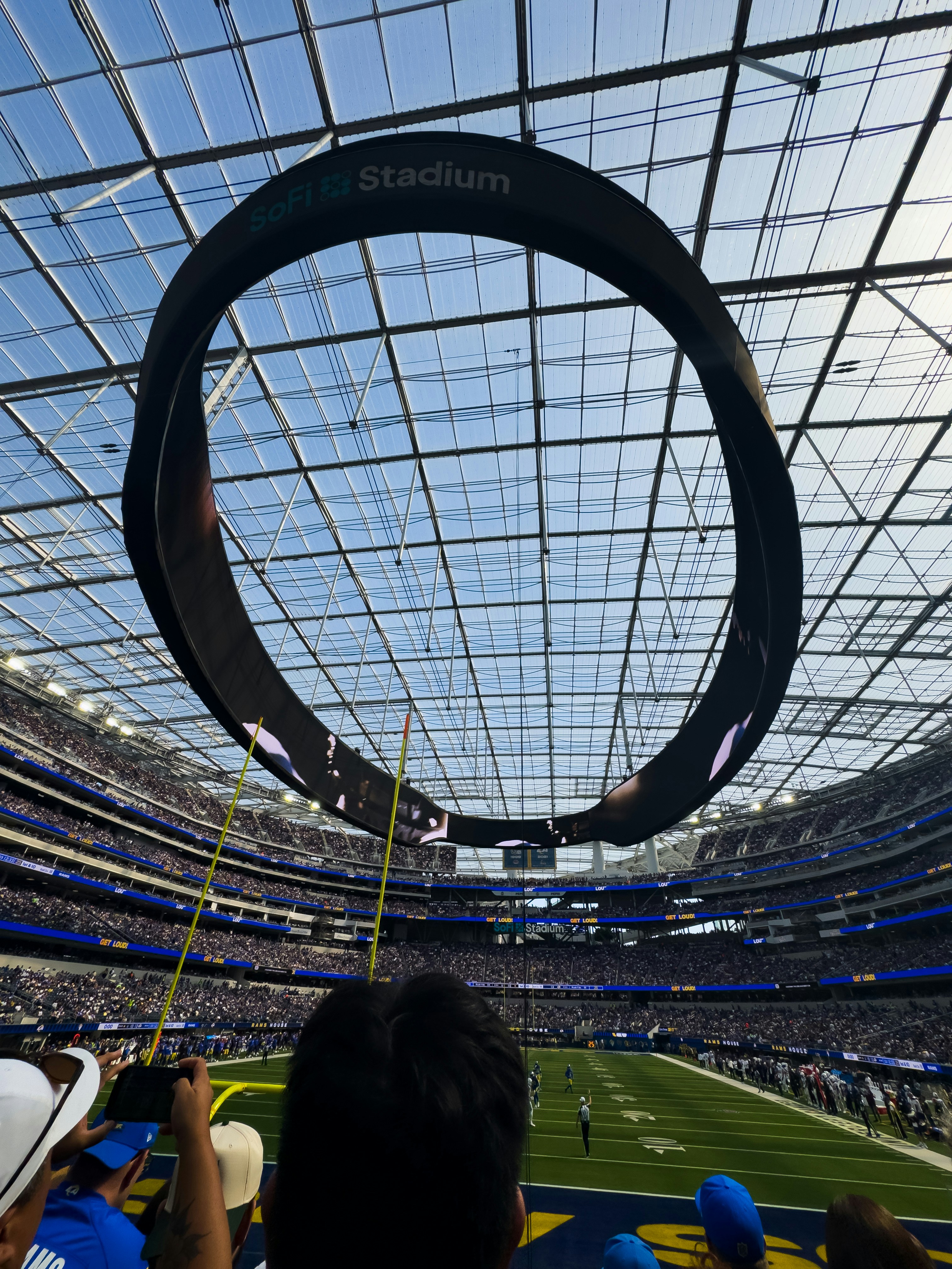 Circular scoreboard above a football stadium field