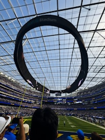 Circular scoreboard above a football stadium field
