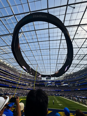 Circular scoreboard above a football stadium field
