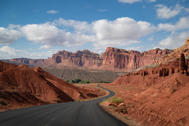 Winding road through a desert landscape with red rock formations.