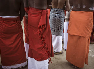 Men wearing traditional sarongs and white lower garments.