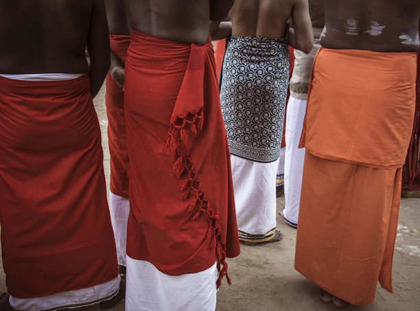 Men wearing traditional sarongs and white lower garments.