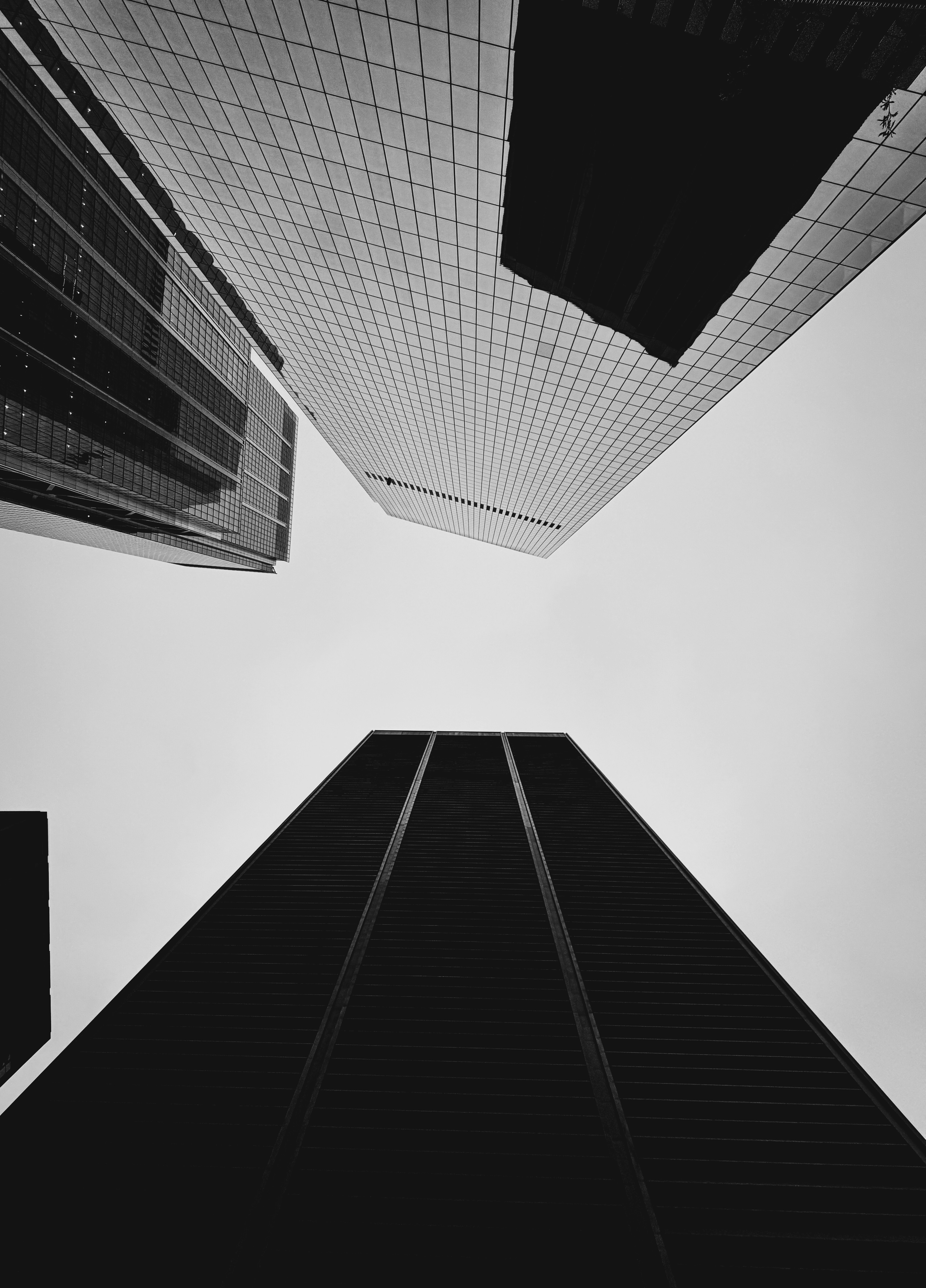 Looking up at modern skyscrapers against a cloudy sky.