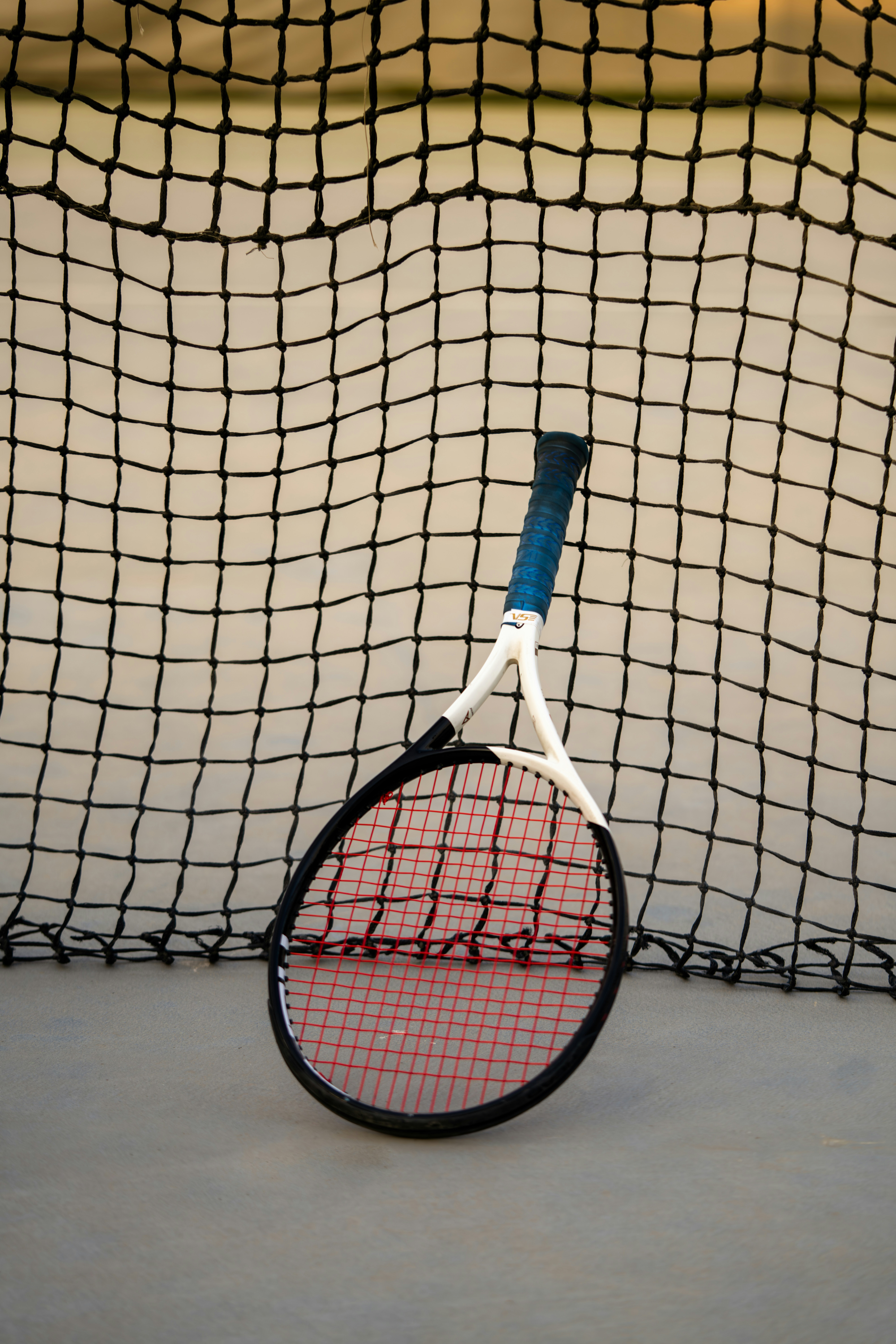Tennis racket leaning against a net