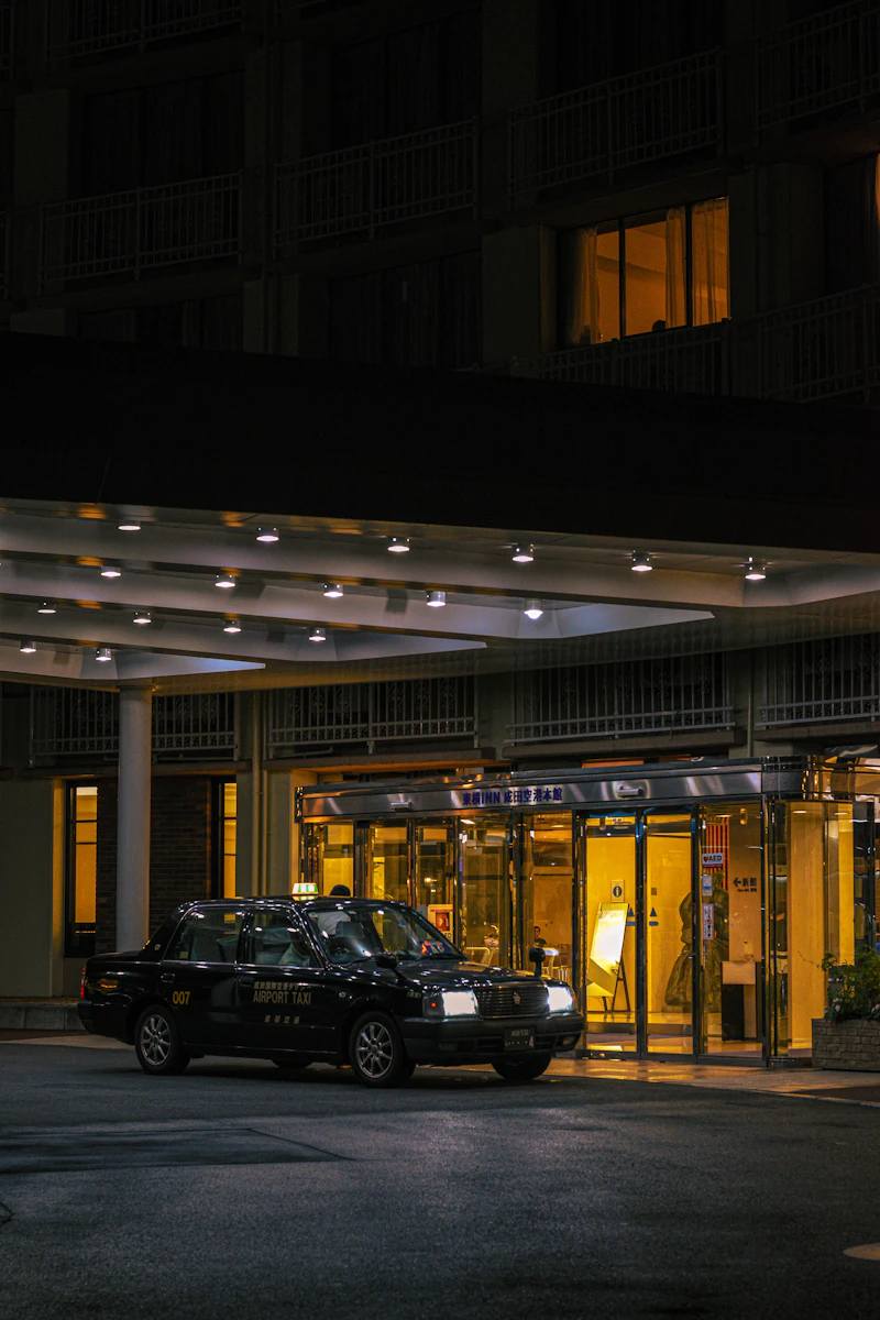 Car waiting outside a brightly lit hotel entrance