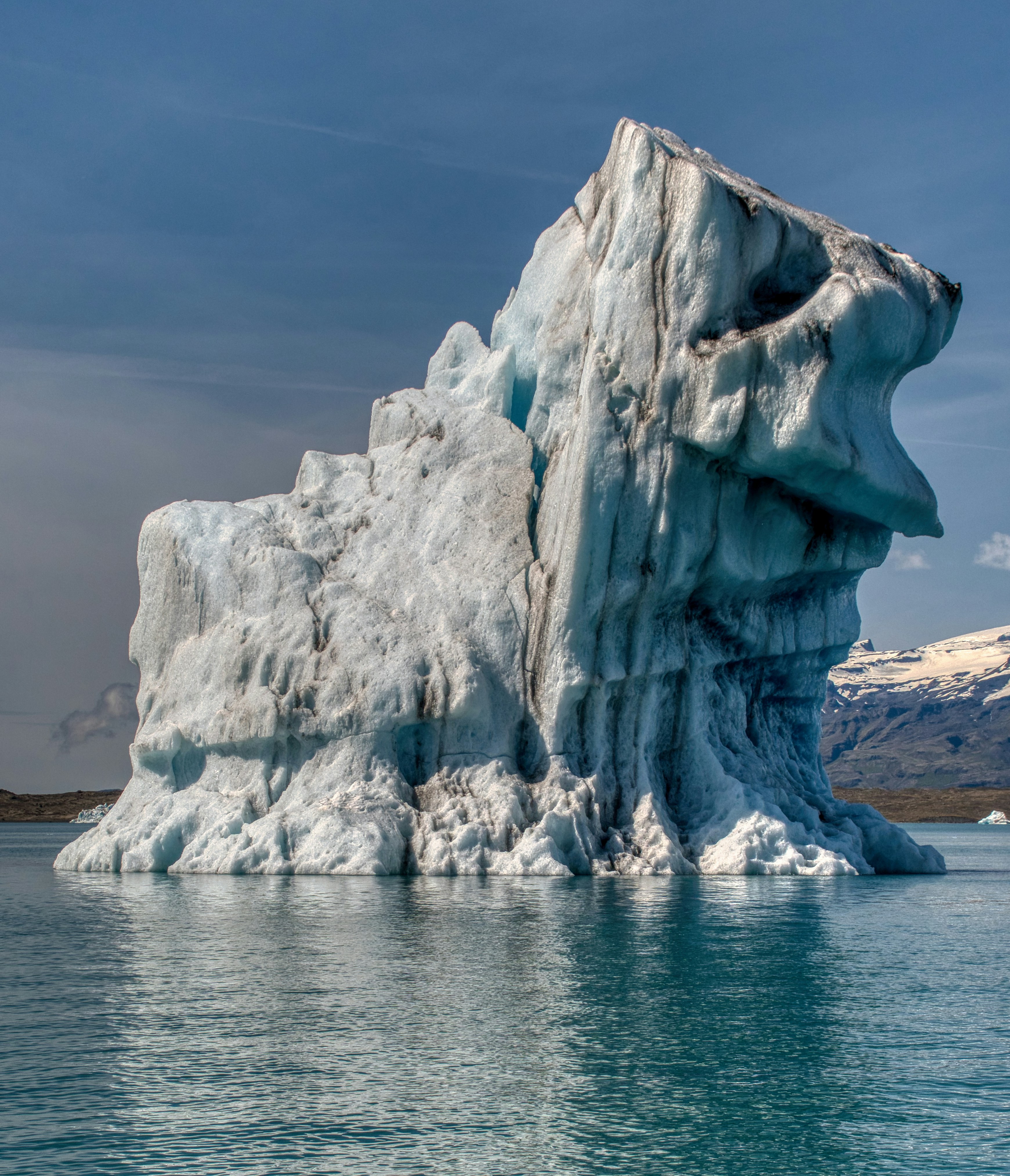 Large iceberg floating in blue ocean water