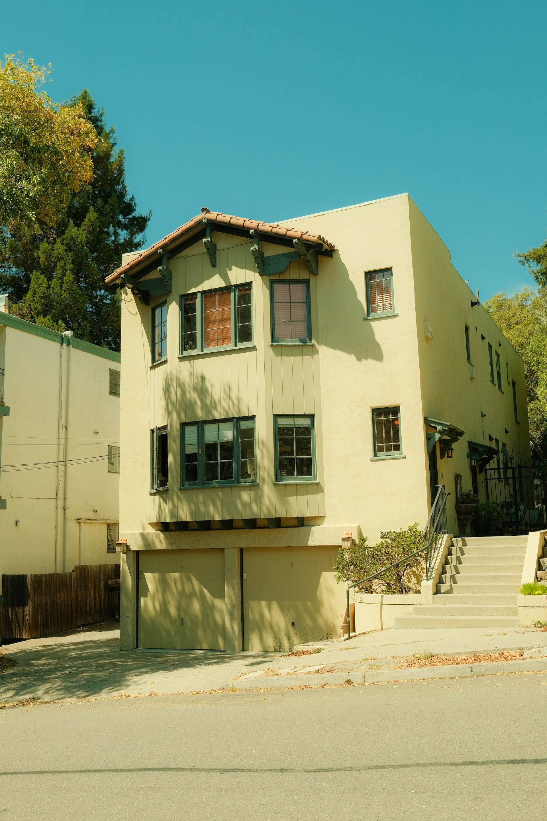 A light yellow house with a garage and stairs.