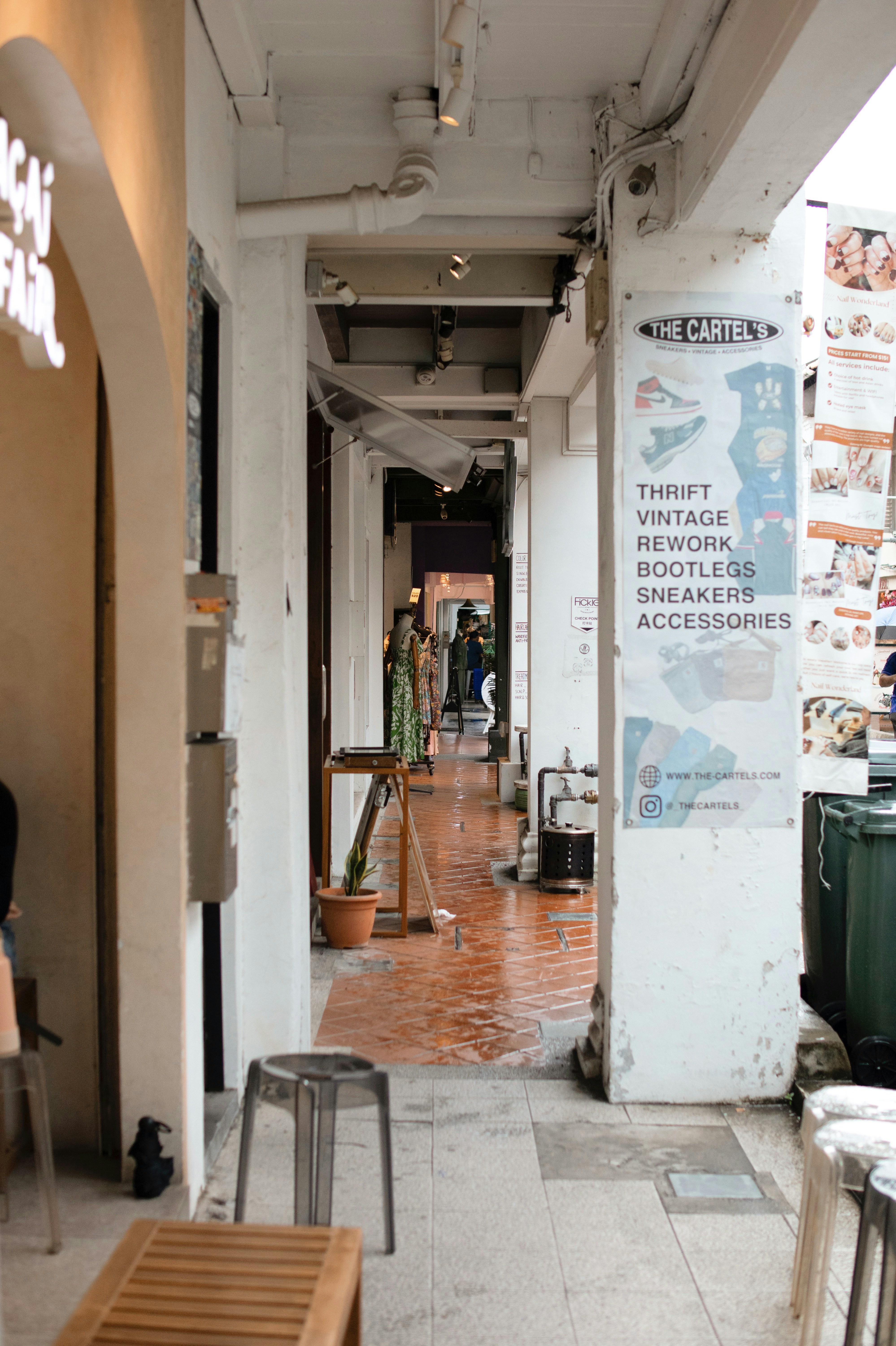 Outdoor walkway with shops and posters