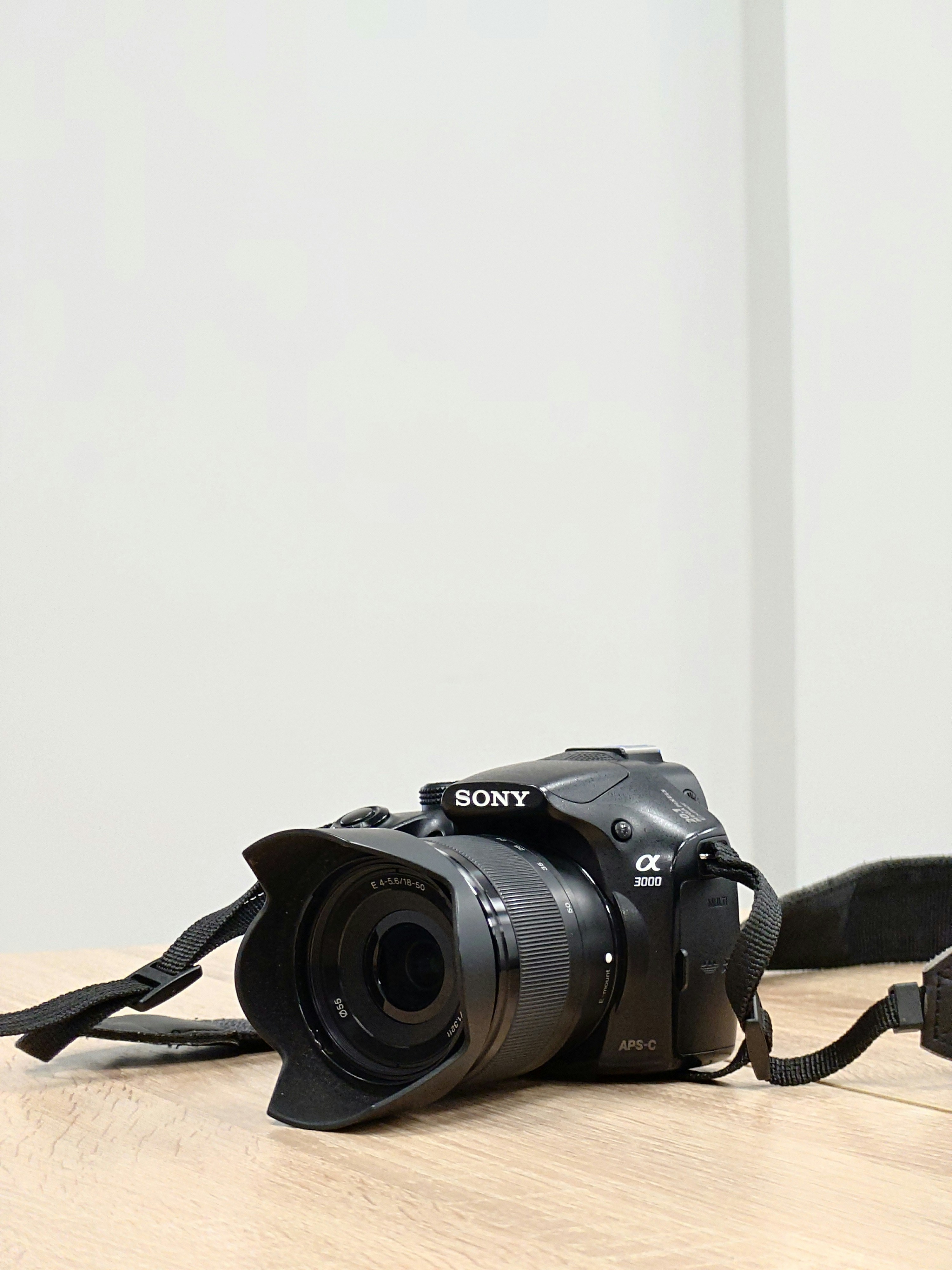 A black Sony DSLR camera with lens and strap.