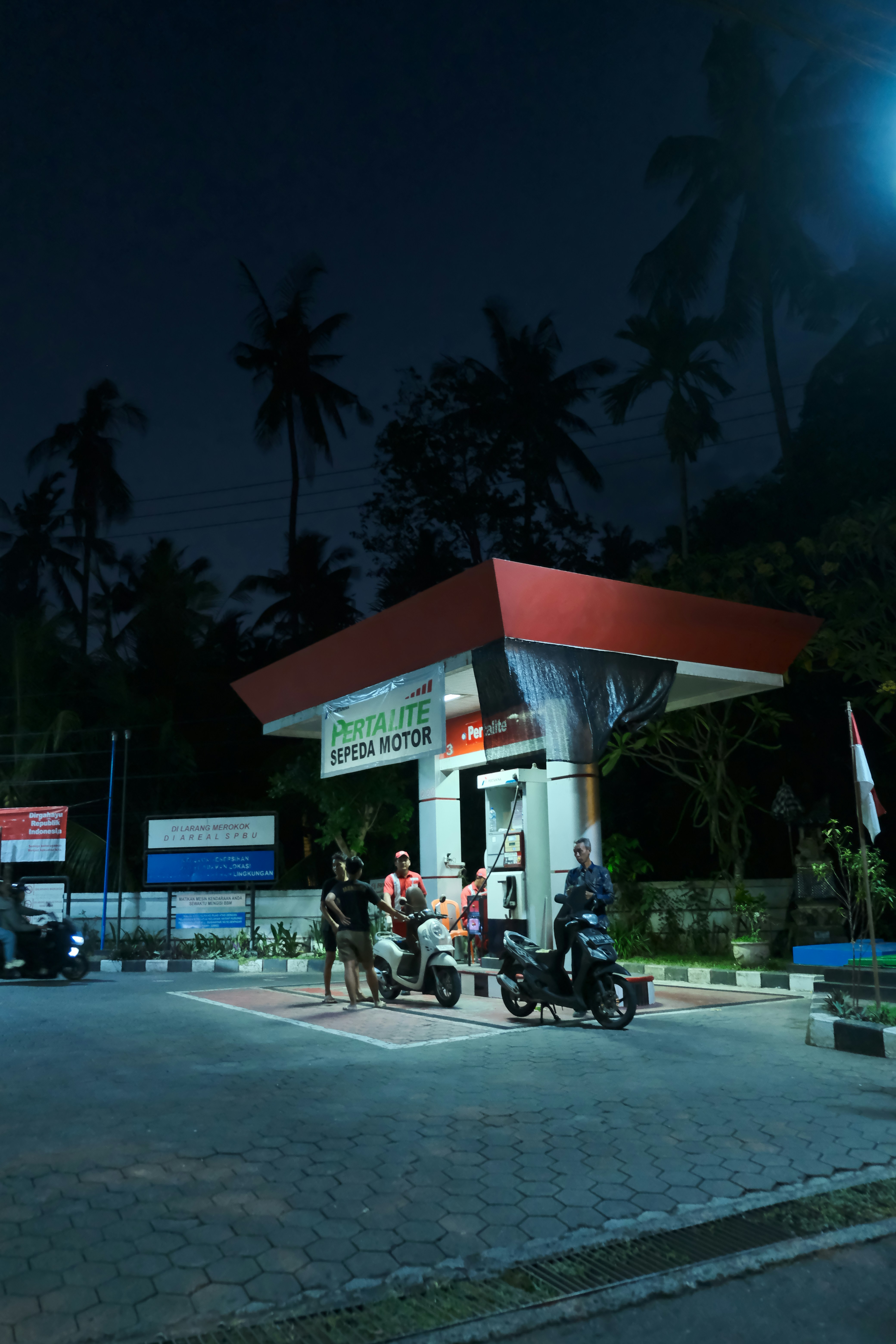 Orang-orang di pompa bensin pada malam hari