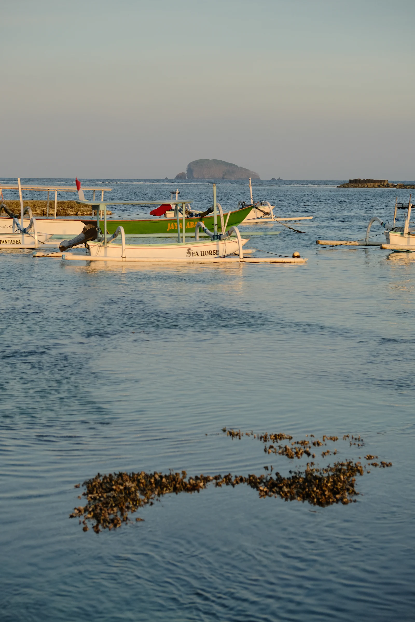 Jukung outrigger boats resting on calm water at dusk in east Bali