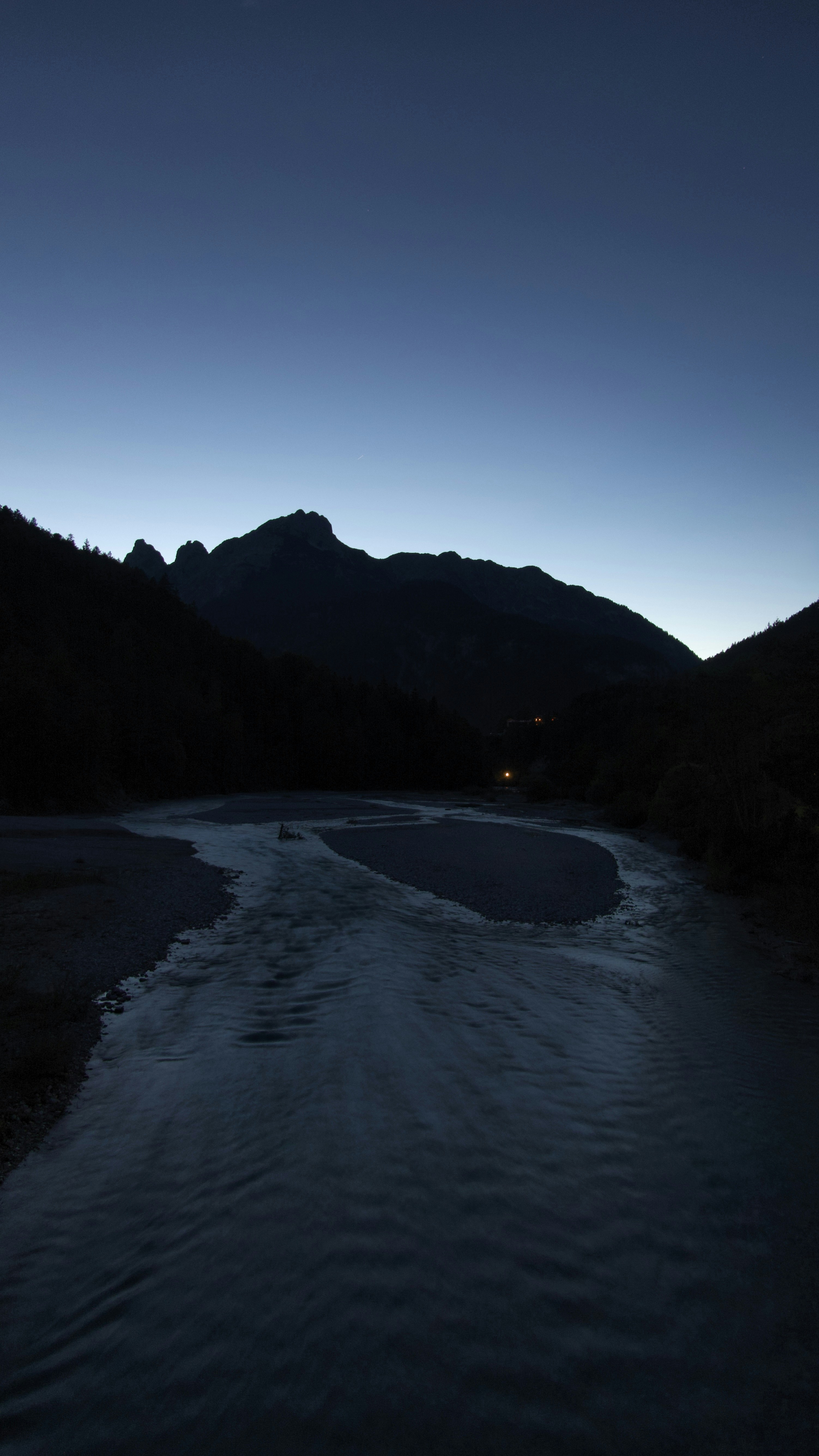Mountain range silhouette at dusk with river