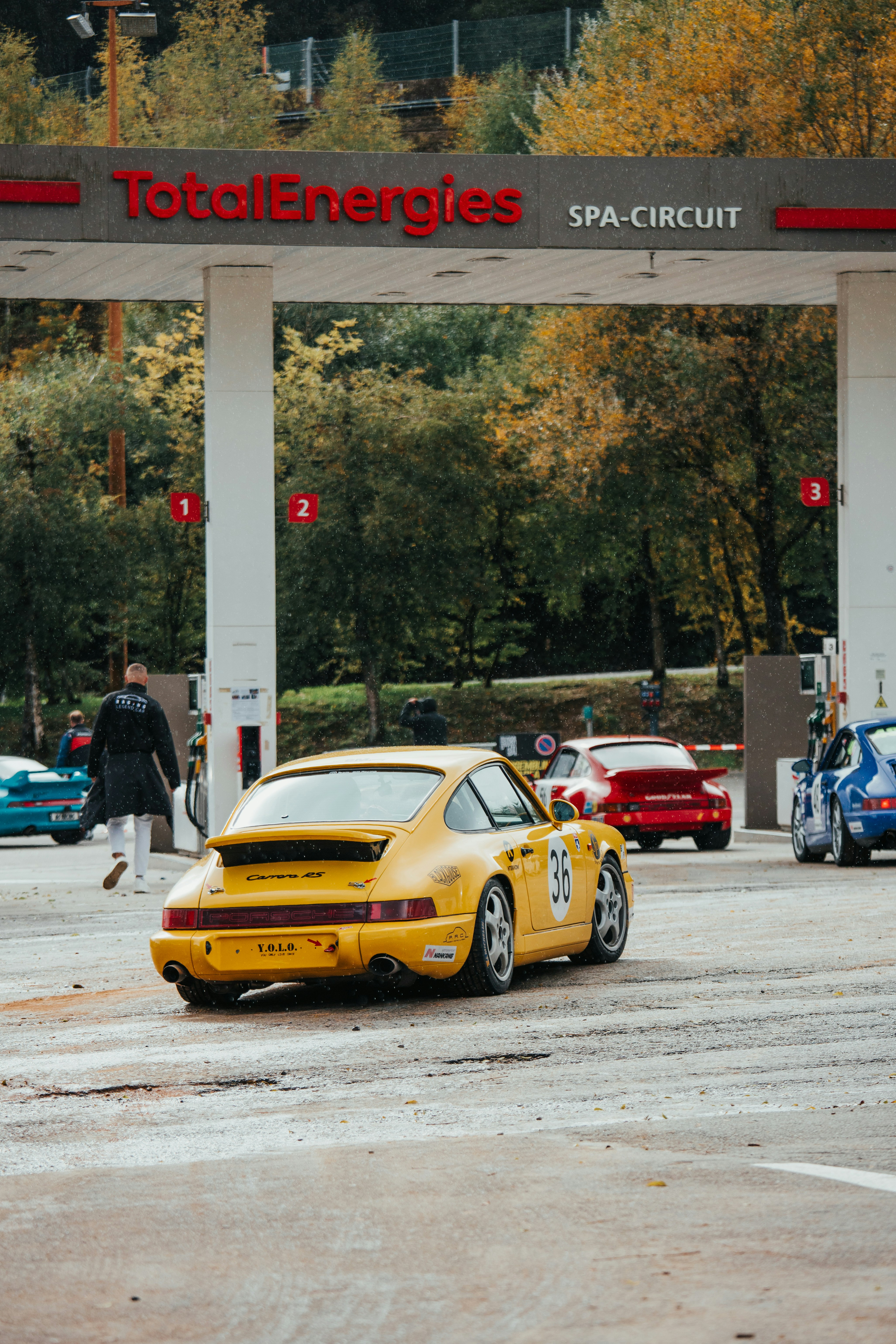 Gelber Porsche fährt durch die Einfahrt des totalenergies Spa-Kreises.