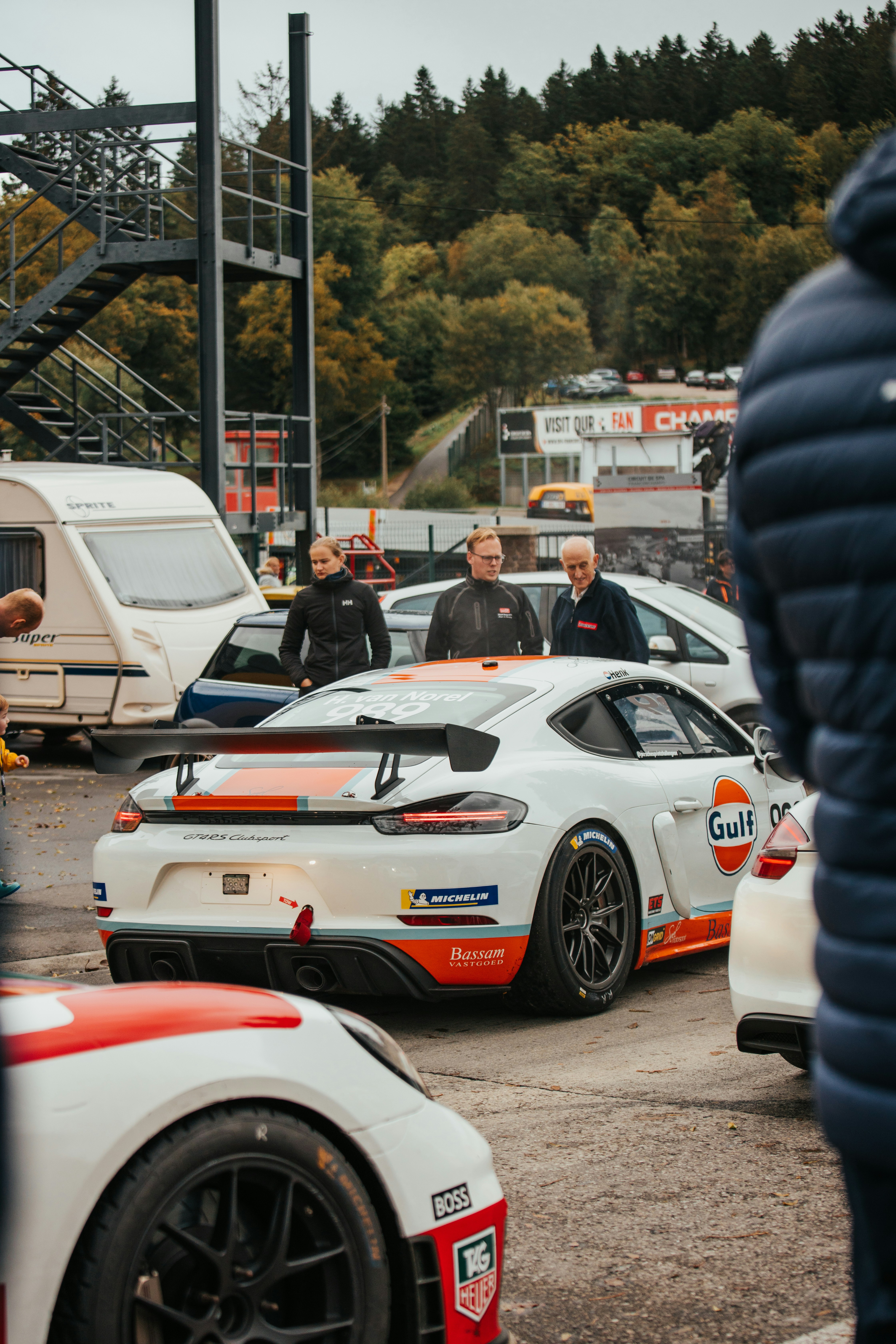 Rennwagen parken an einer Strecke mit Zuschauern, die die Menge beobachten